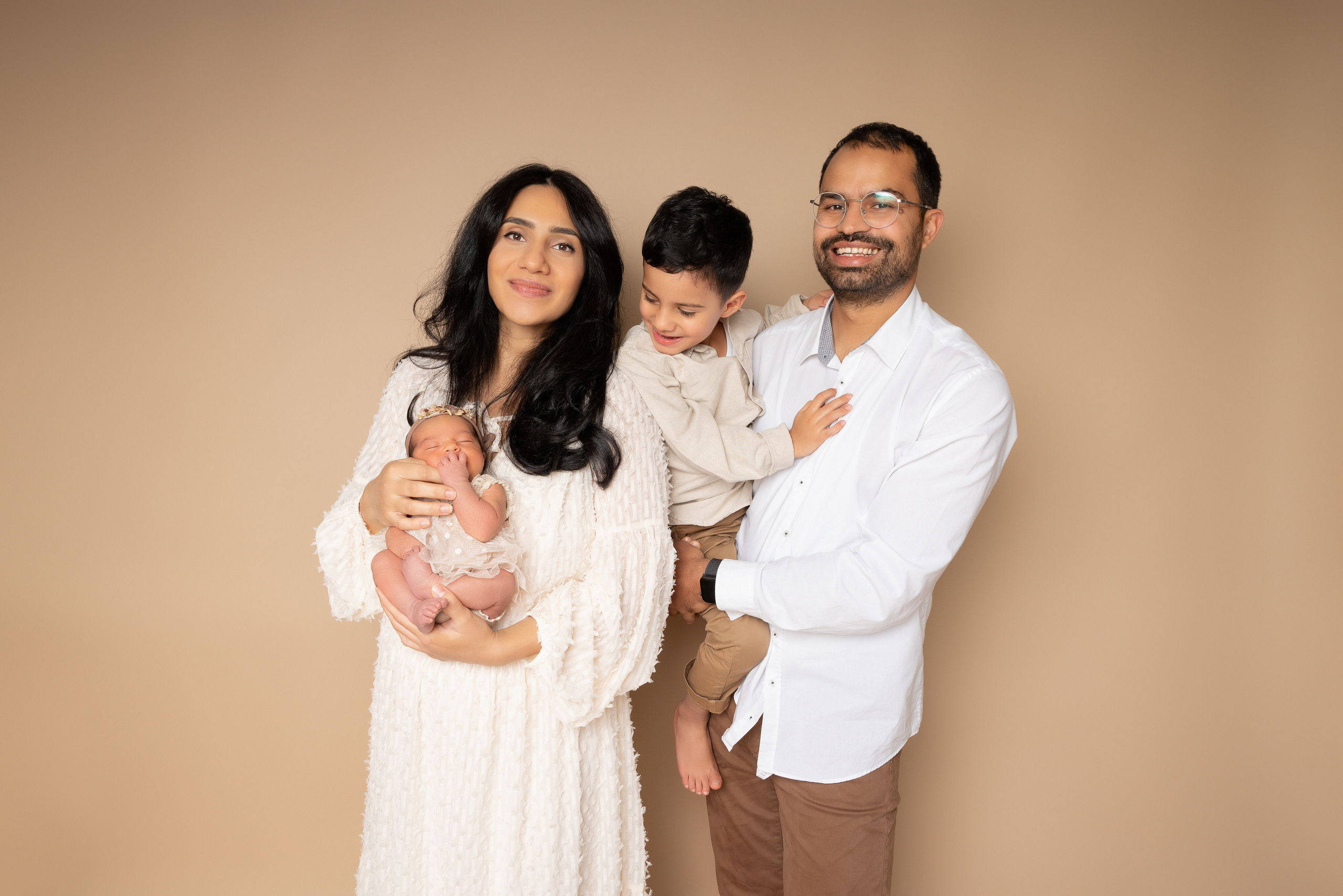 Mutter hält das Baby in ihren Armen und Vater hält den ältesten Sohn