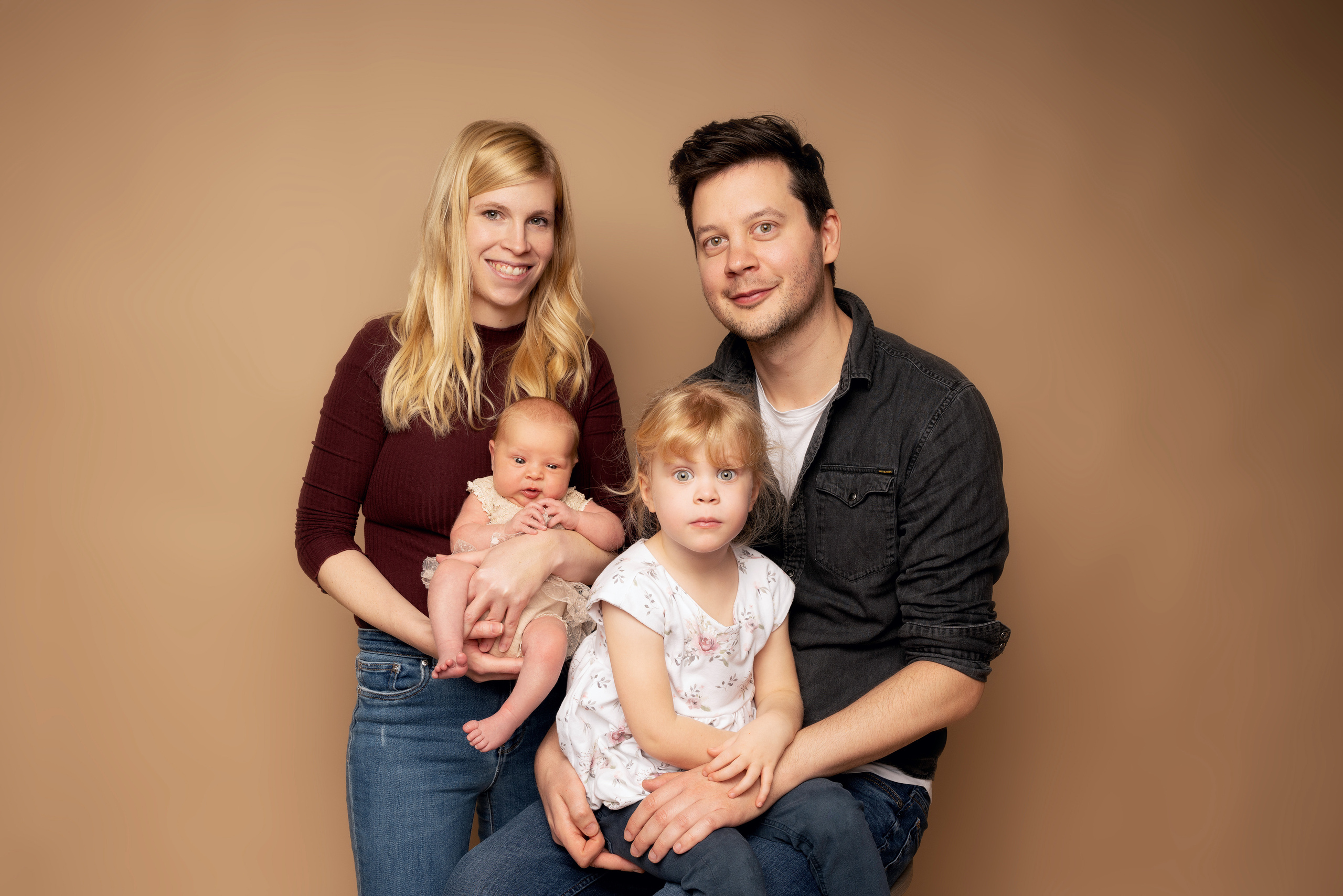 Das Baby ist in rosa eingekleidet und wird von seiner Familie umsorgt