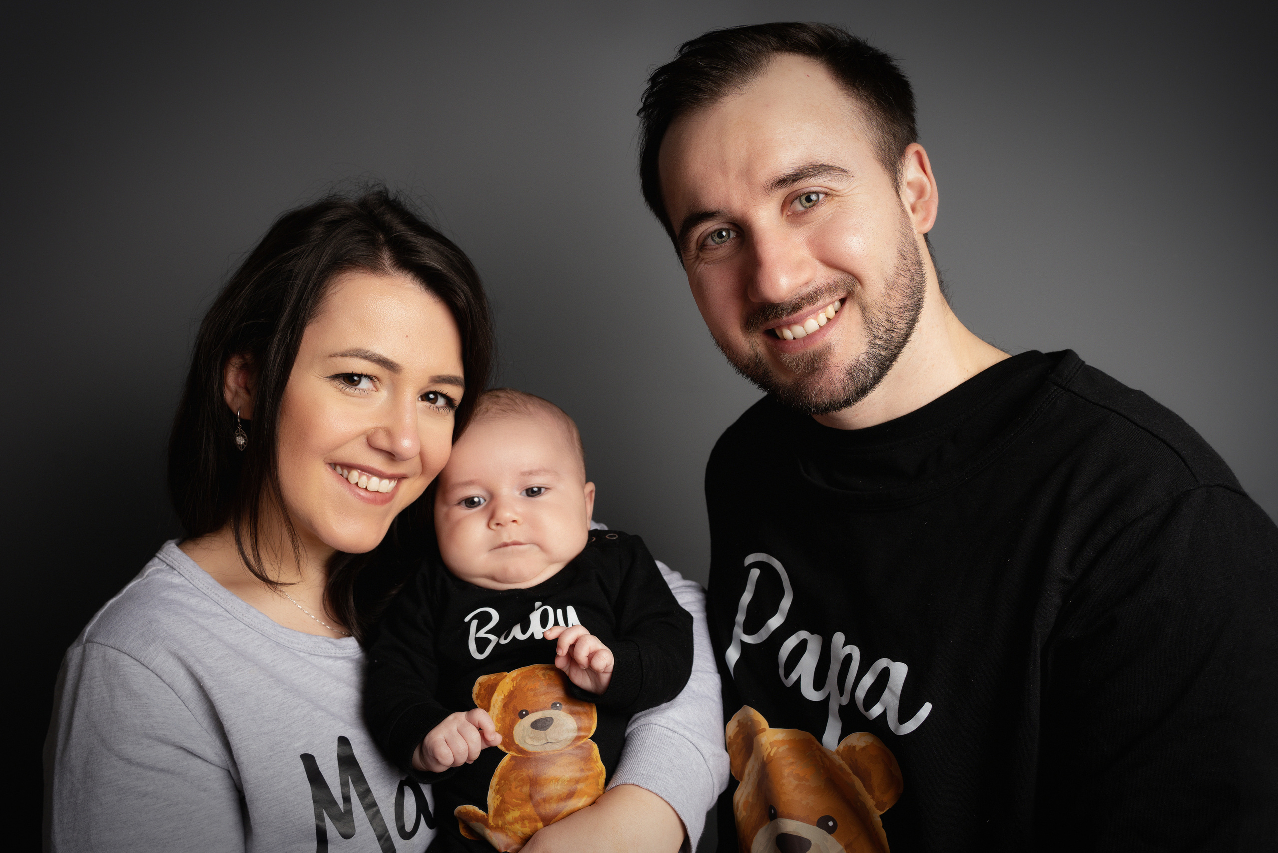 Foto einer jungen Familie auf grauem Hintergrund