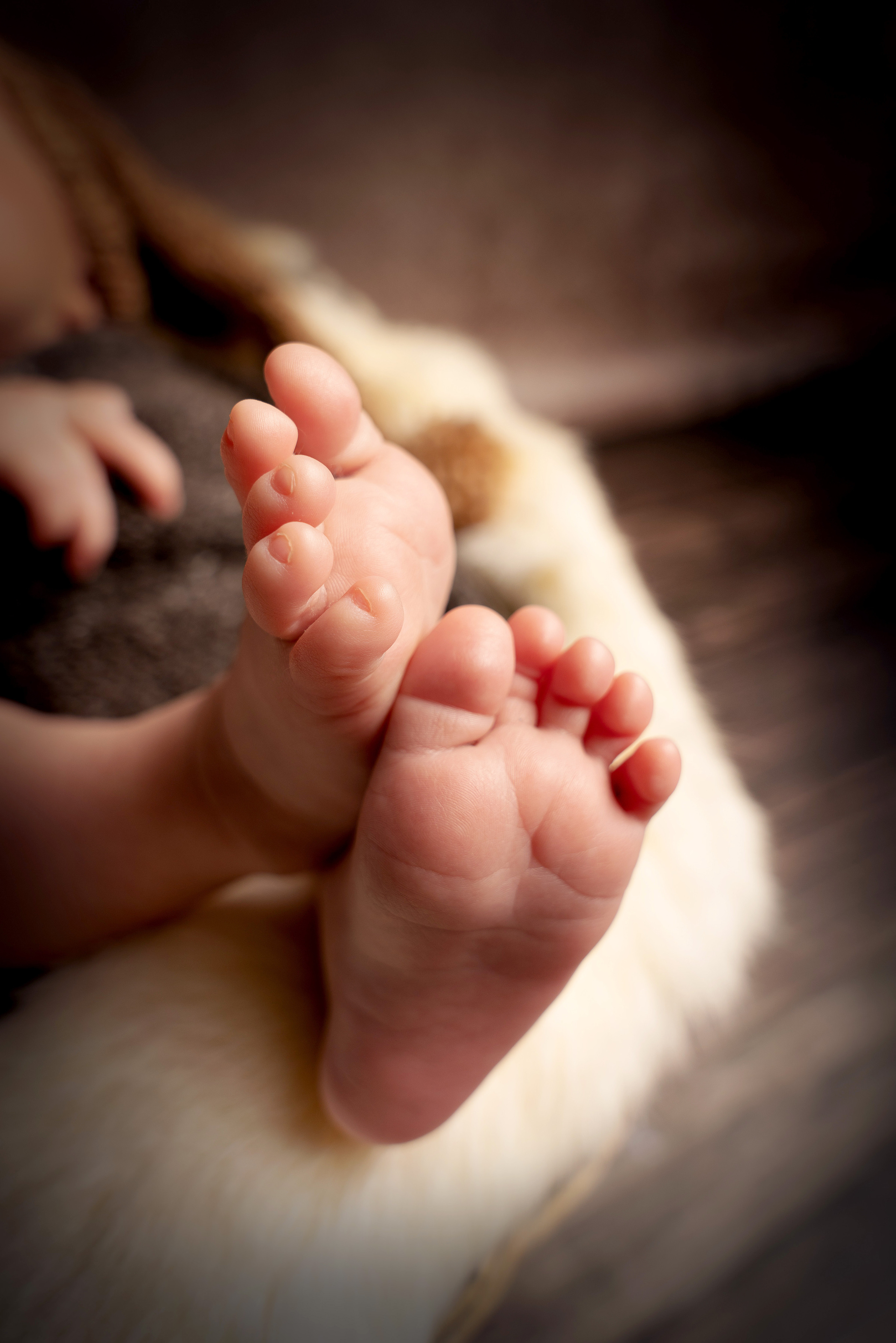 Ein neugeborener Junge hält seine Füße