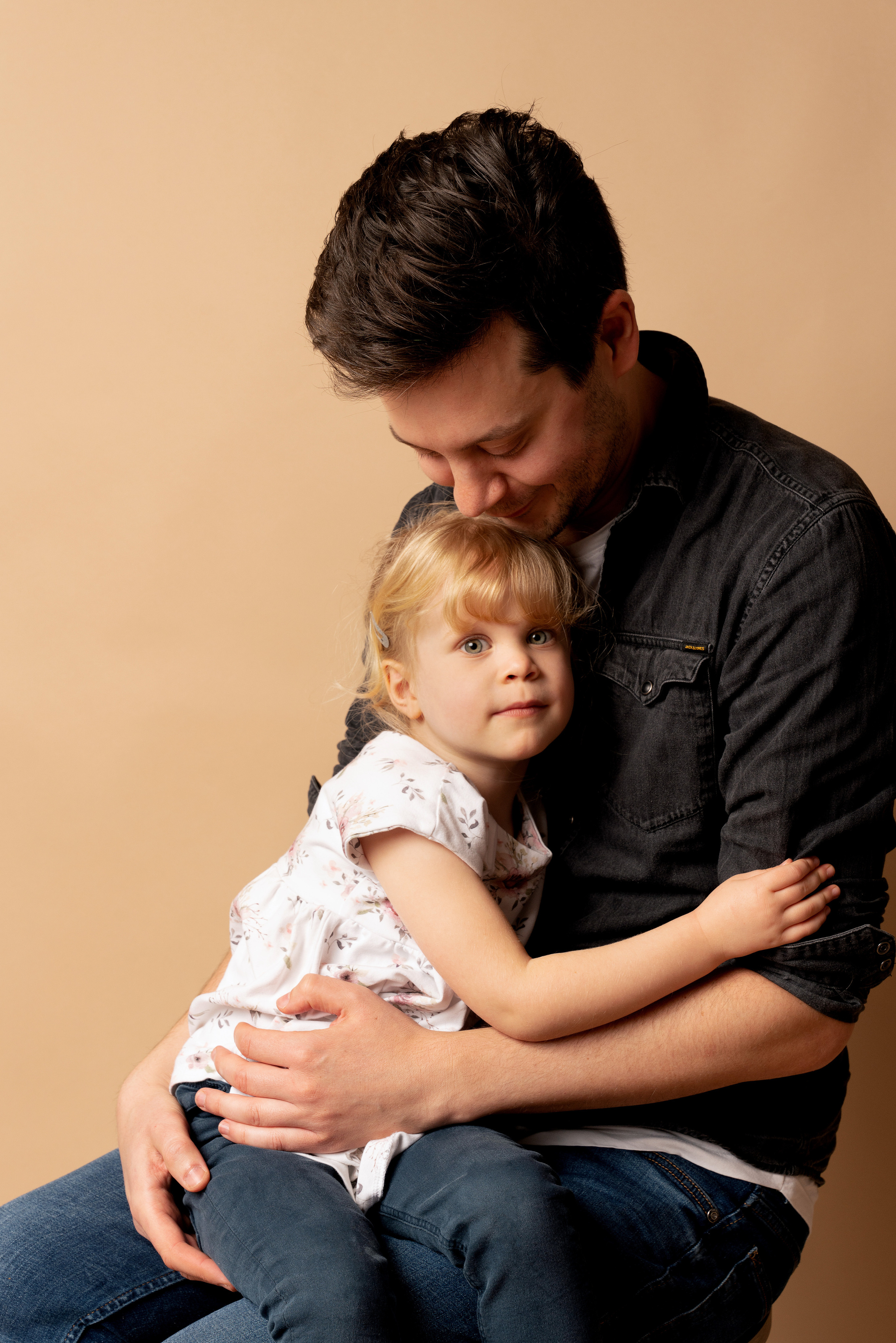 Ein kleiner Engel sitzt mit Papa auf dem Stuhl