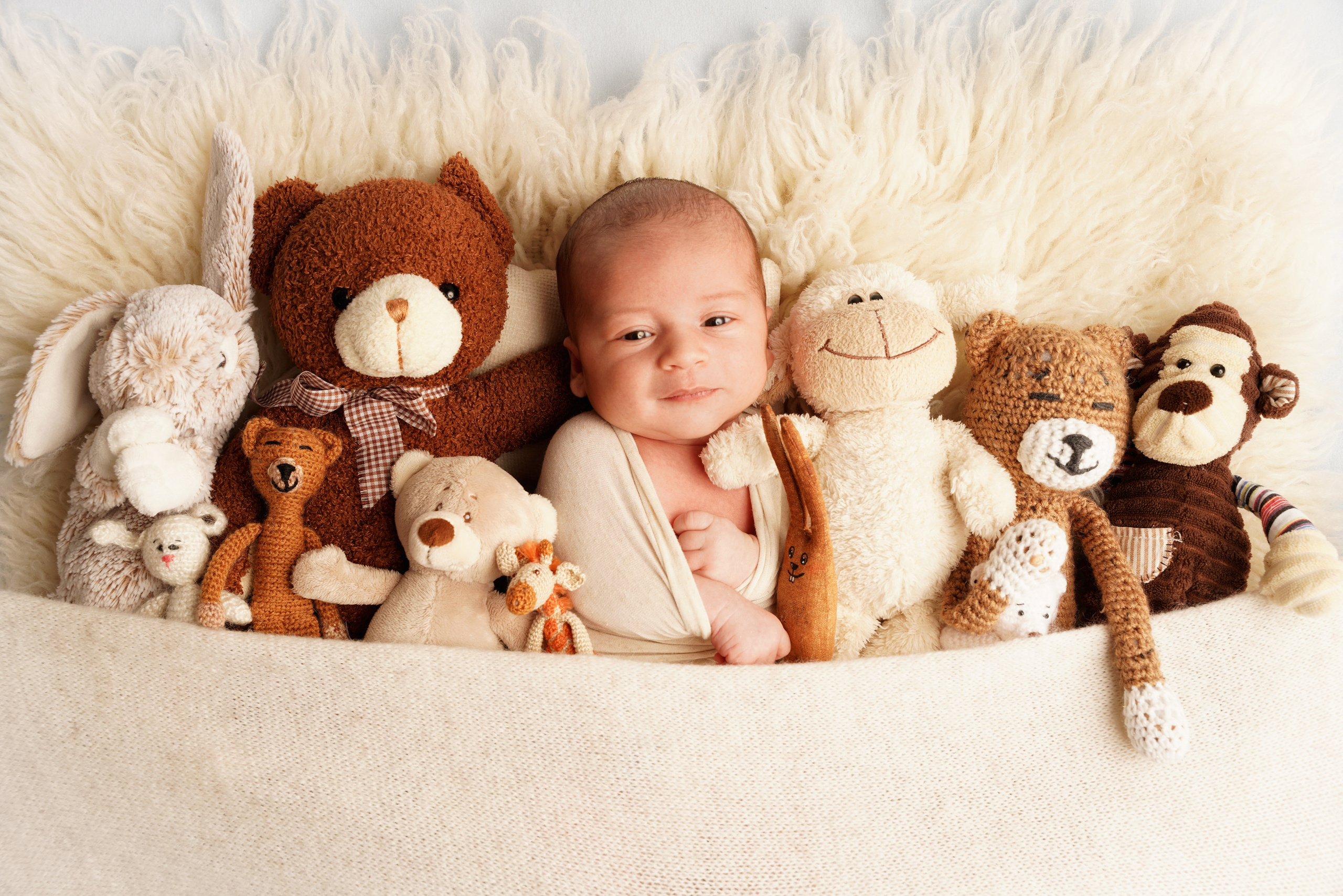 Das Baby ist eingewickelt in eine kuschelige, warme Decke und lächelt verträumt