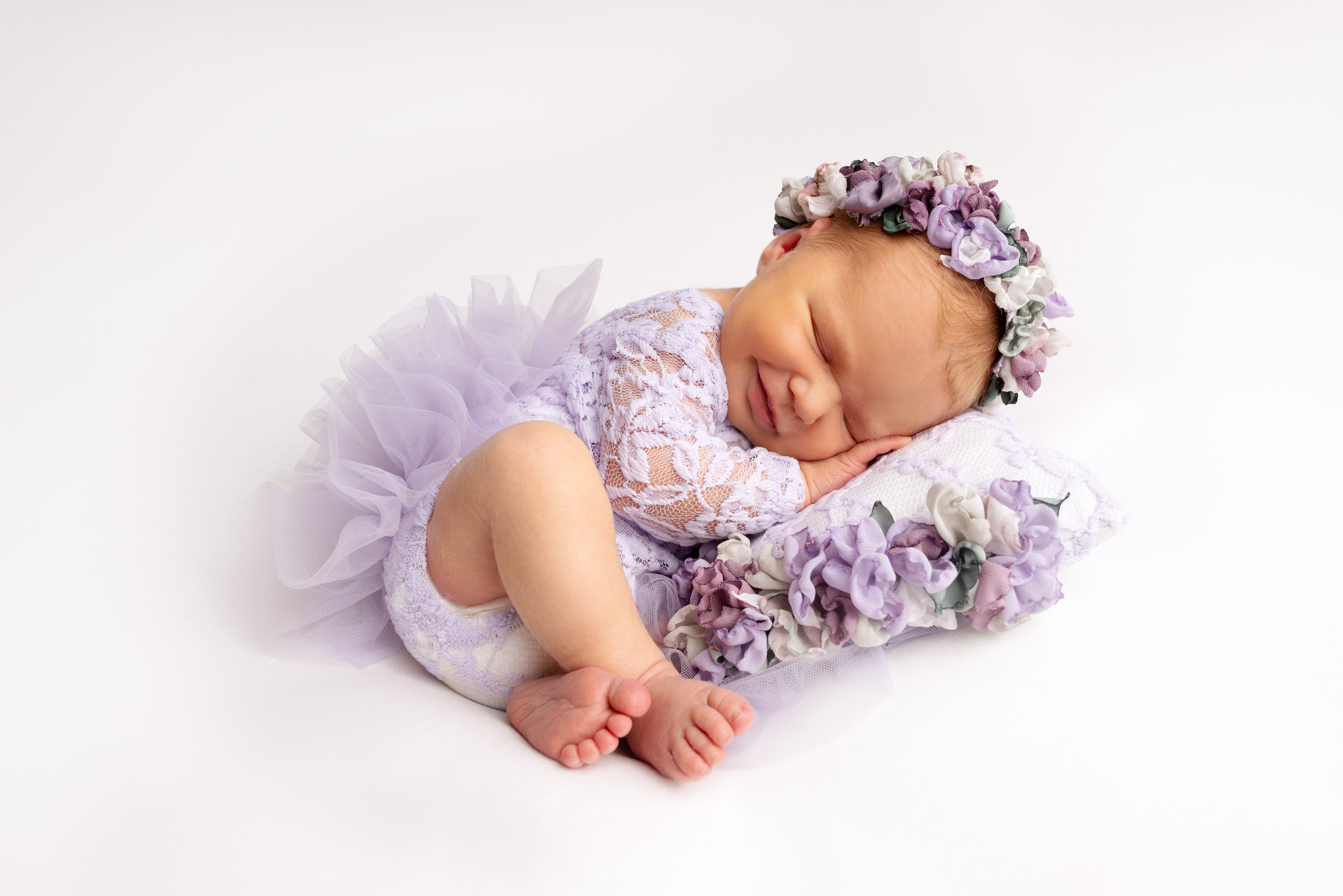 Ein kleines Mädchen hält ihre Füße und lächelt