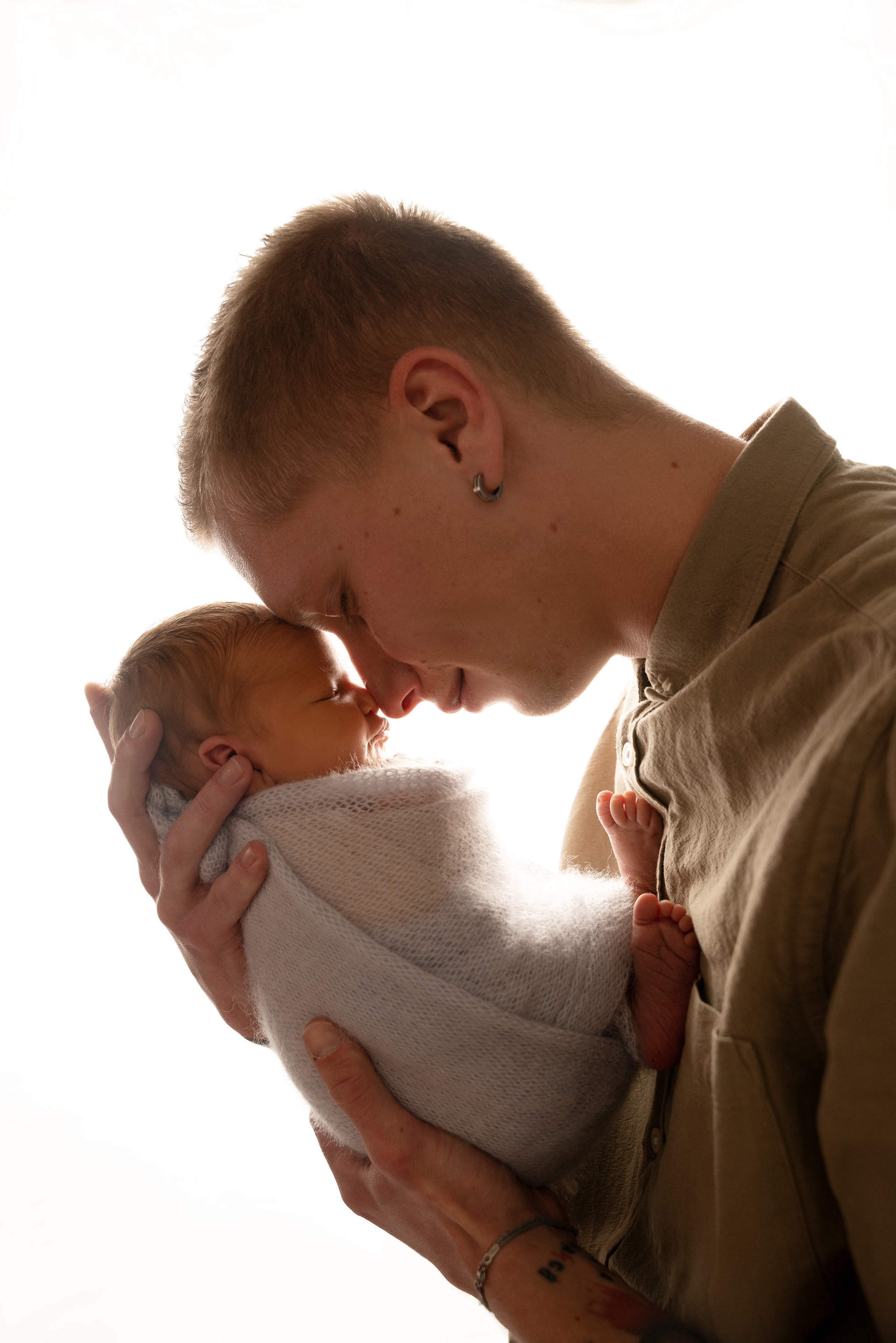 Ein zufriedenes Baby, das im Arm seines Papas schläft