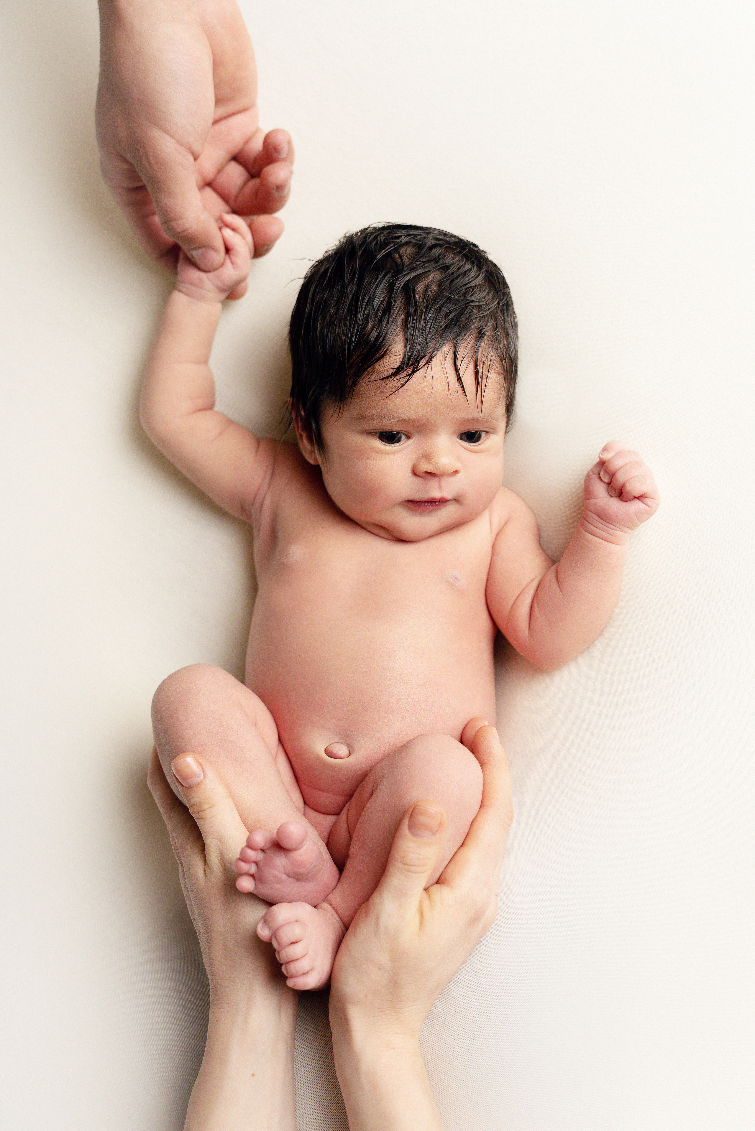 Eine zarte Babyhand hält den Finger der Mutter fest