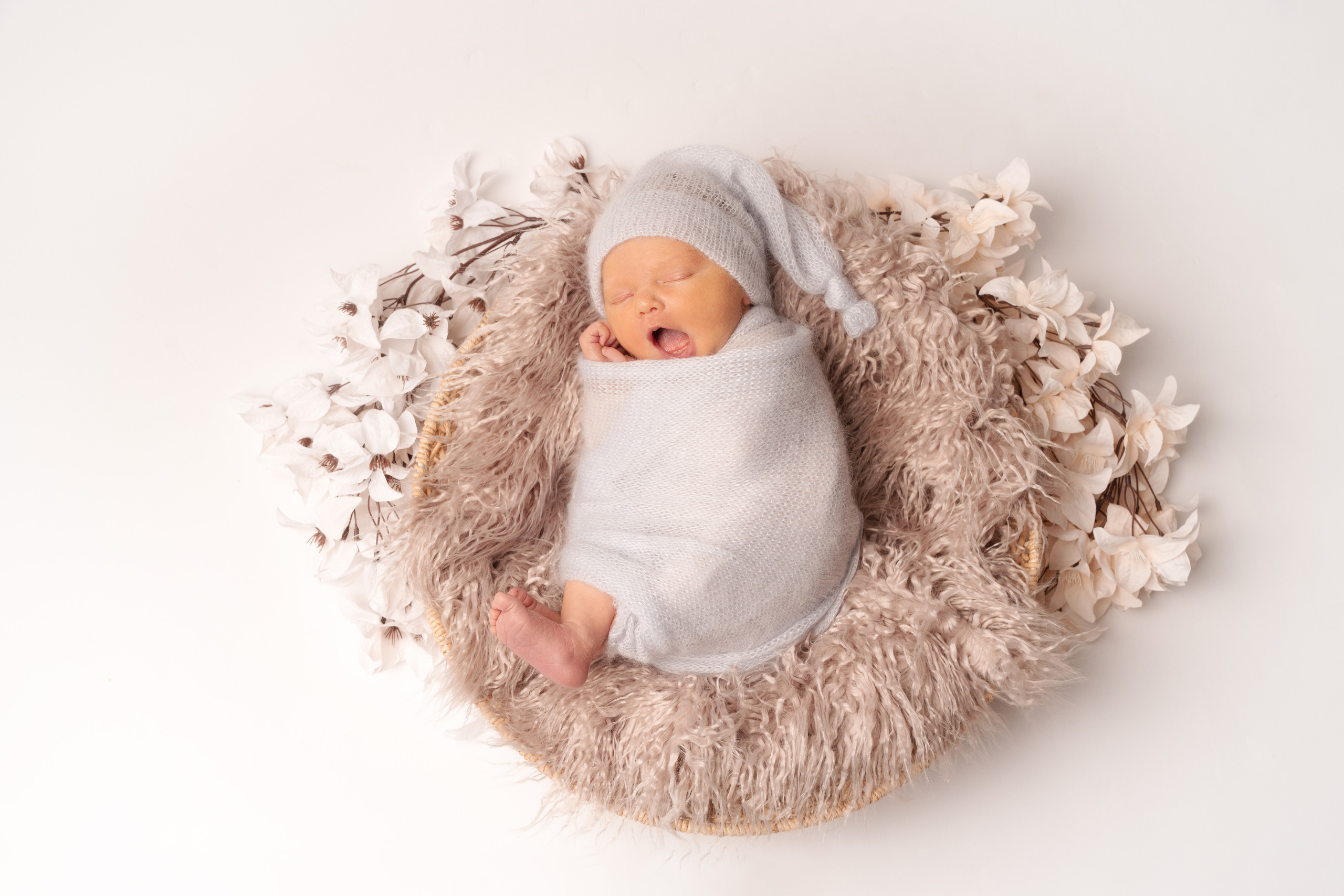 Ein neugeborenes Mädchen in einem Korb mit Blumen