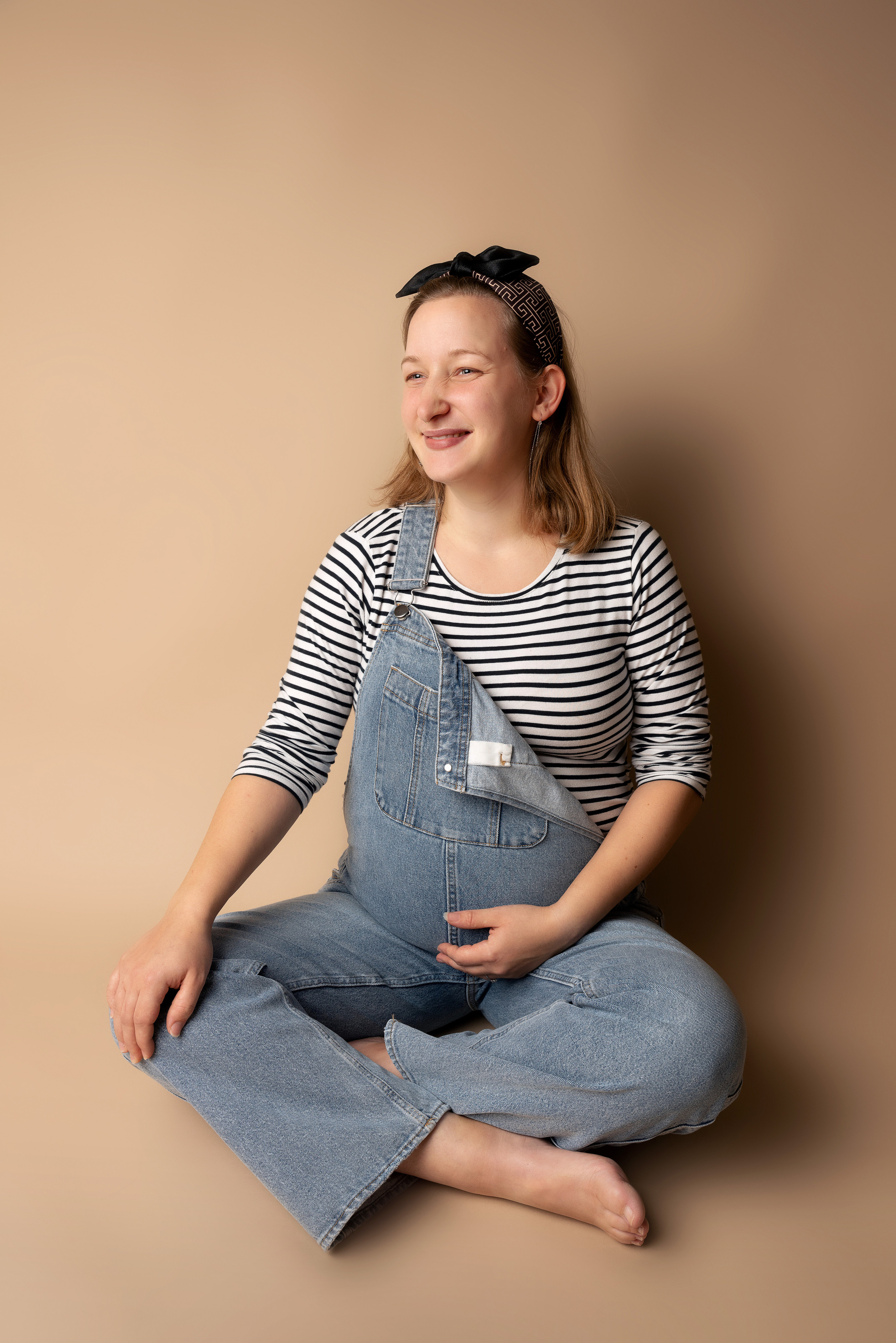 Eine schwangere Frau ruht sich auf einem Boden aus und liest ein Buch