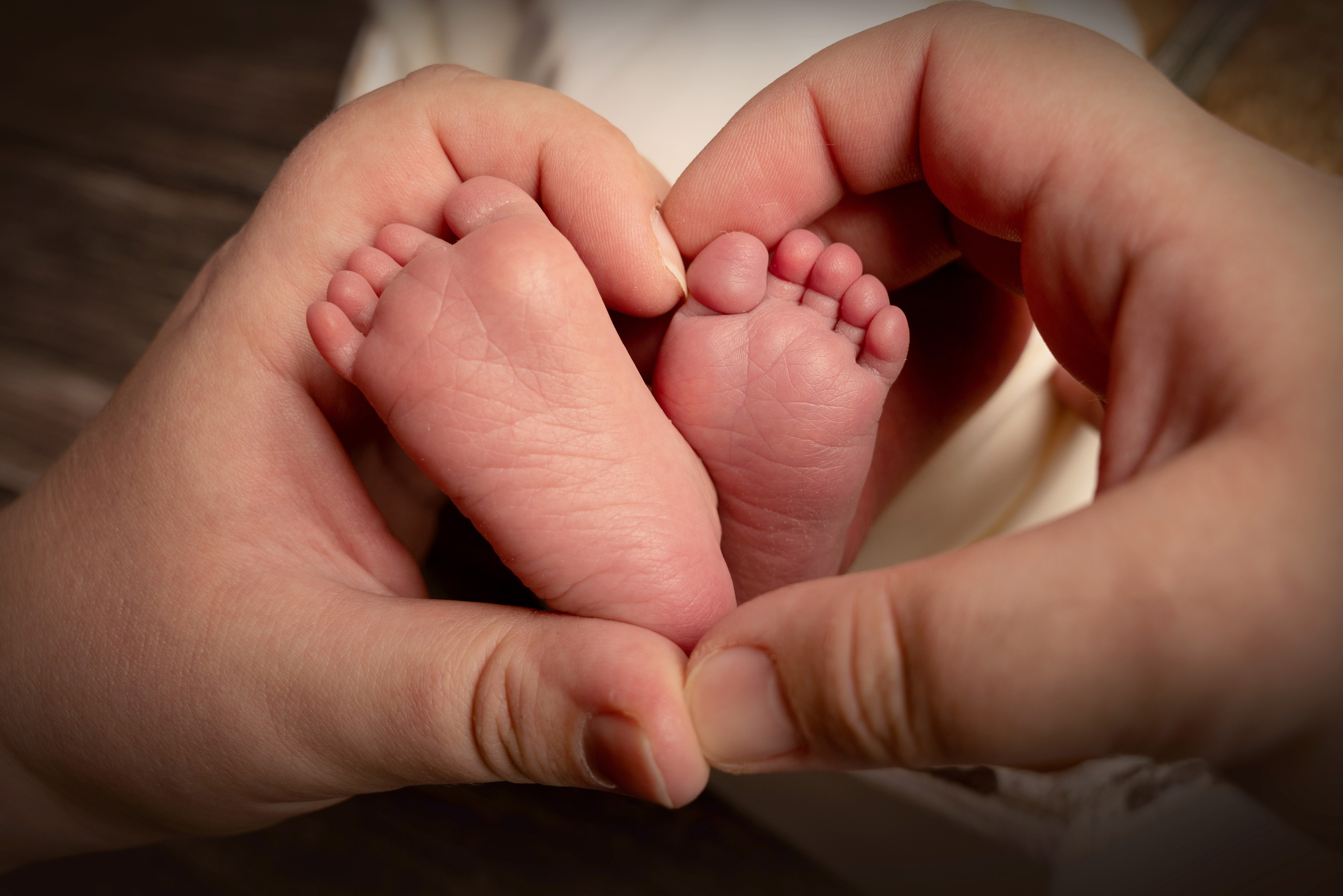 Zwei kleine Füße, die aus einer Decke hervorschauen