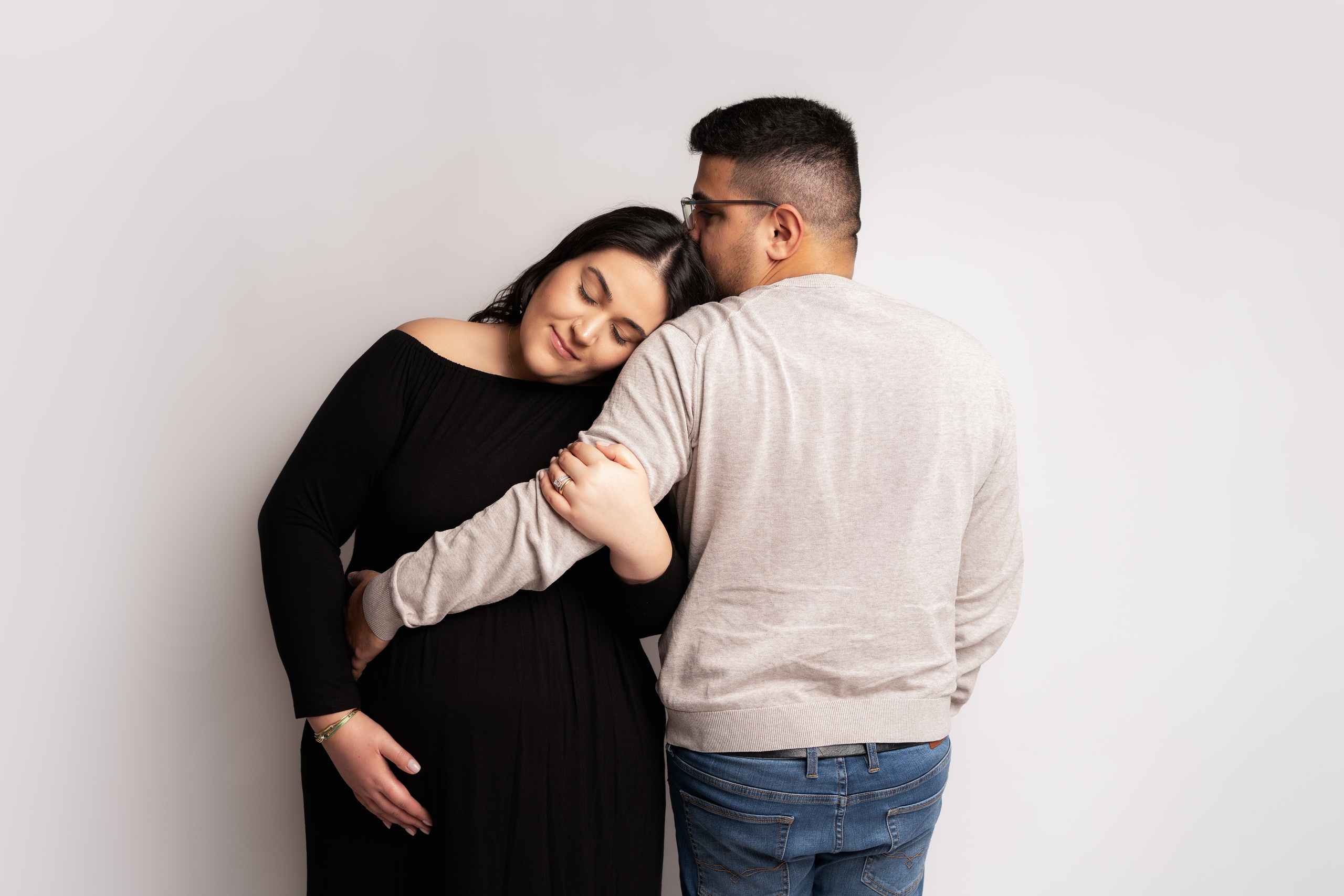 Ein glückliches Paar umarmt sich und zeigt stolz den Schwangerschaftstest