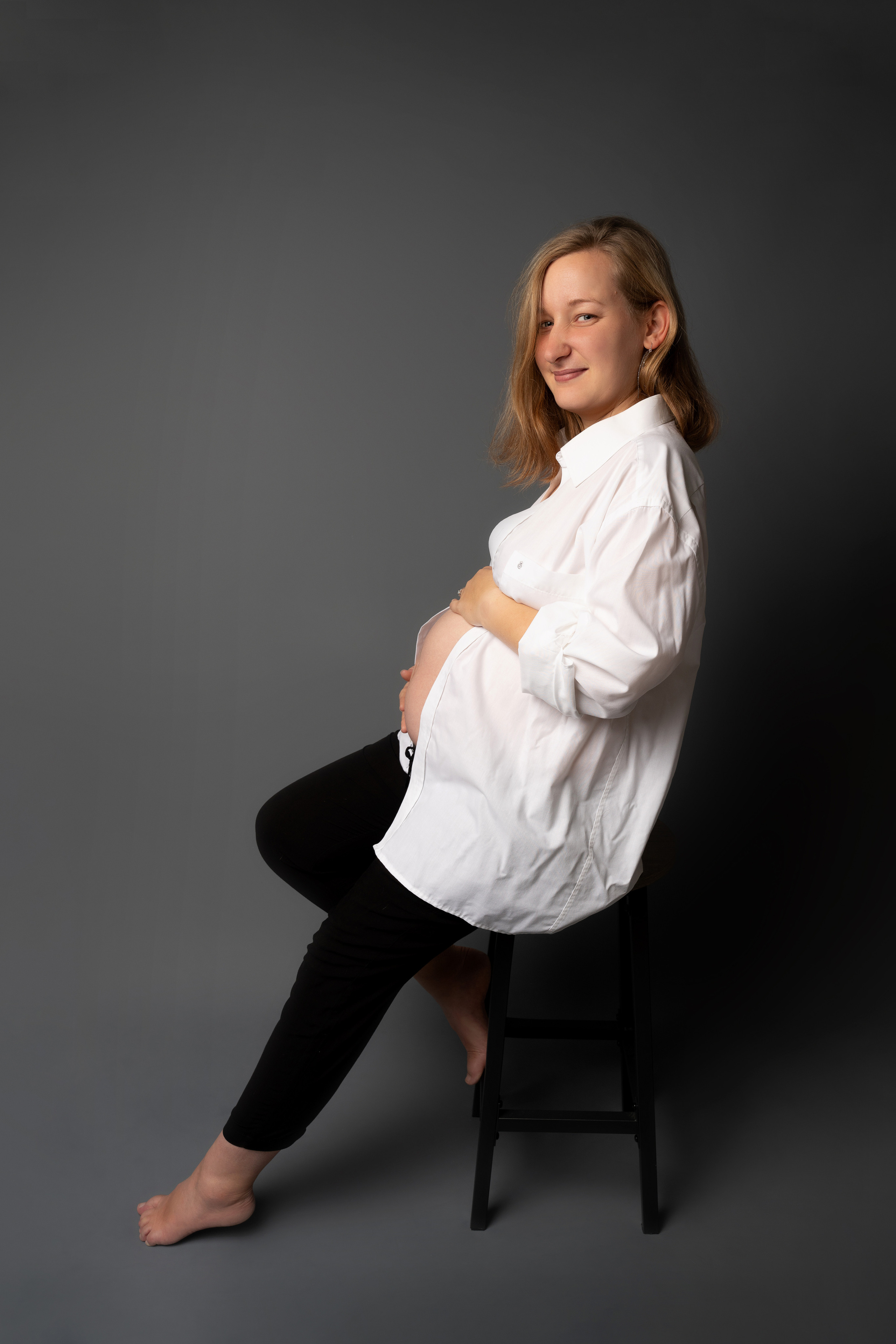 Eine schwangere Frau sitzt auf einem Stuhl und betrachtet die Aussicht