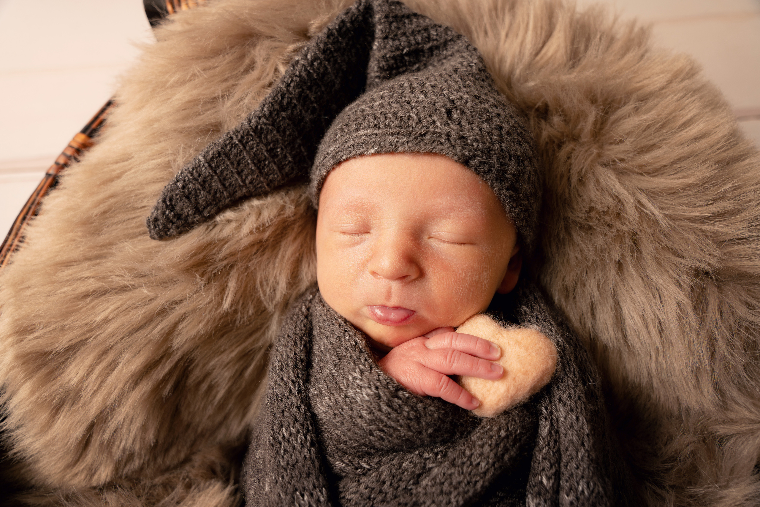 Ein süßes kleines Baby hält seine Hände zusammen