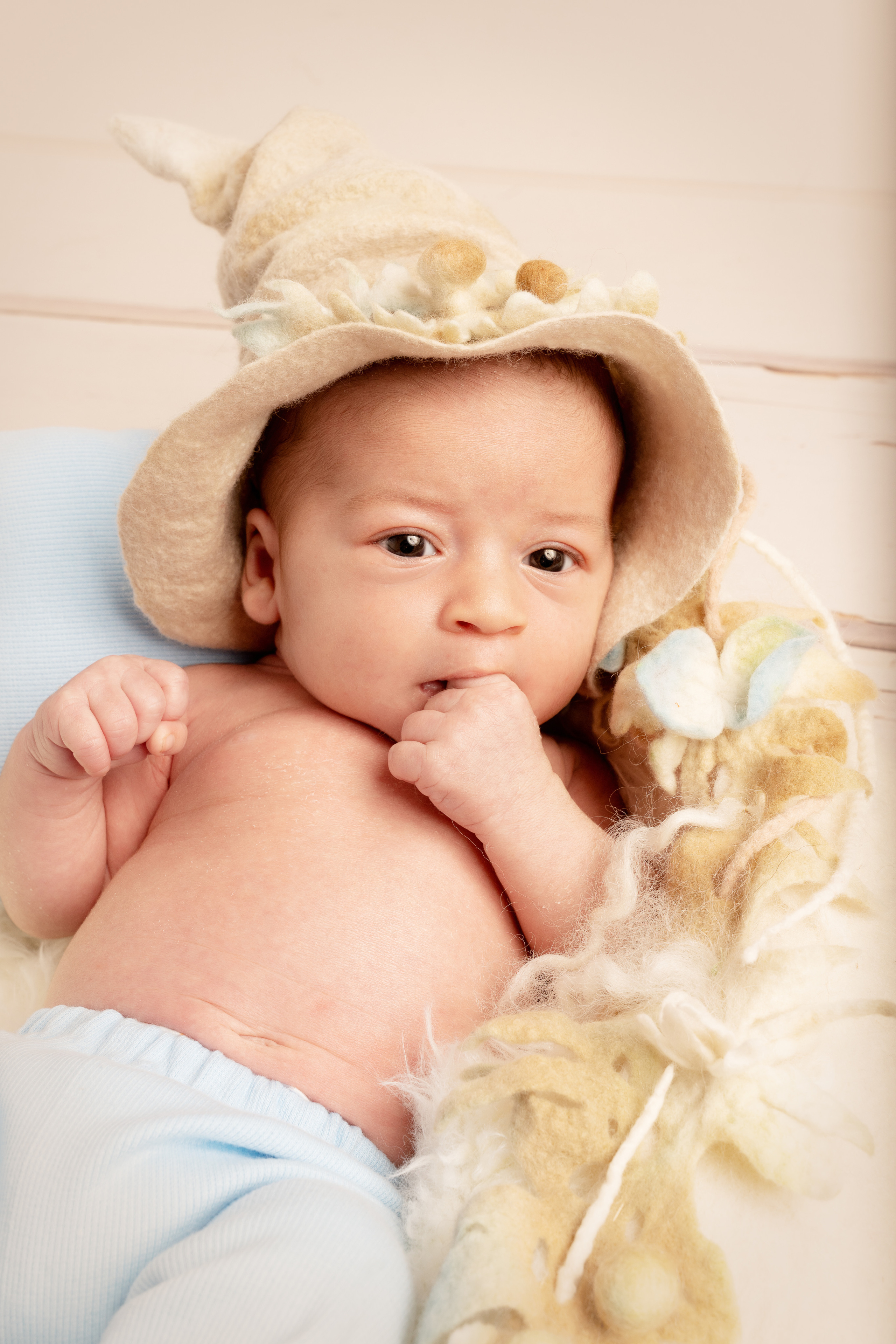 Das Baby schaut mit großen Augen in die Kamera und strahlt Freude aus