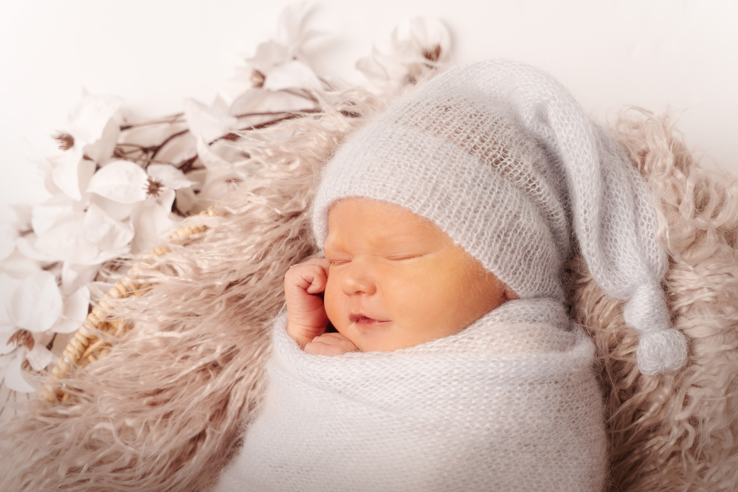 Ein kleines Mädchen posiert auf einer Decke mit Blumen