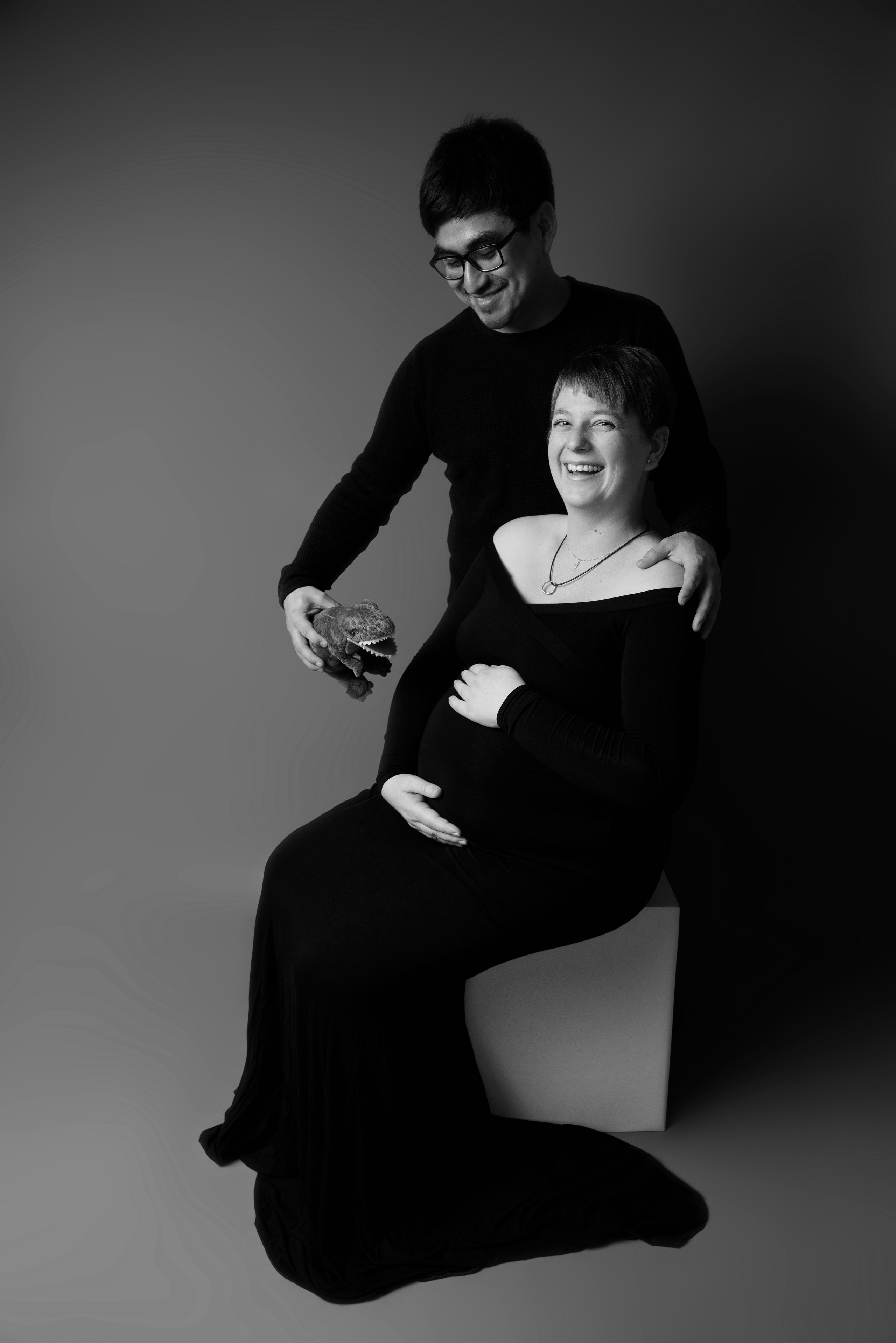 Ein Paar sitzt auf einer Bank und hält ein Ultraschallbild