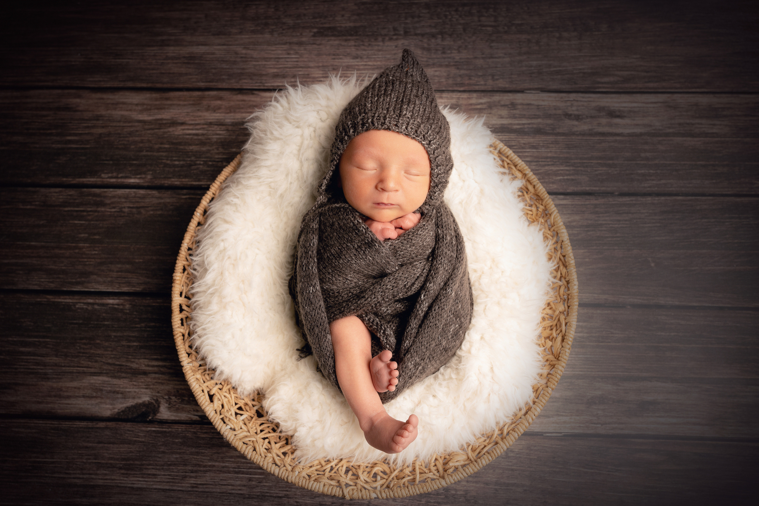 Ein fröhliches Neugeborenes schläft friedlich in einem Korb