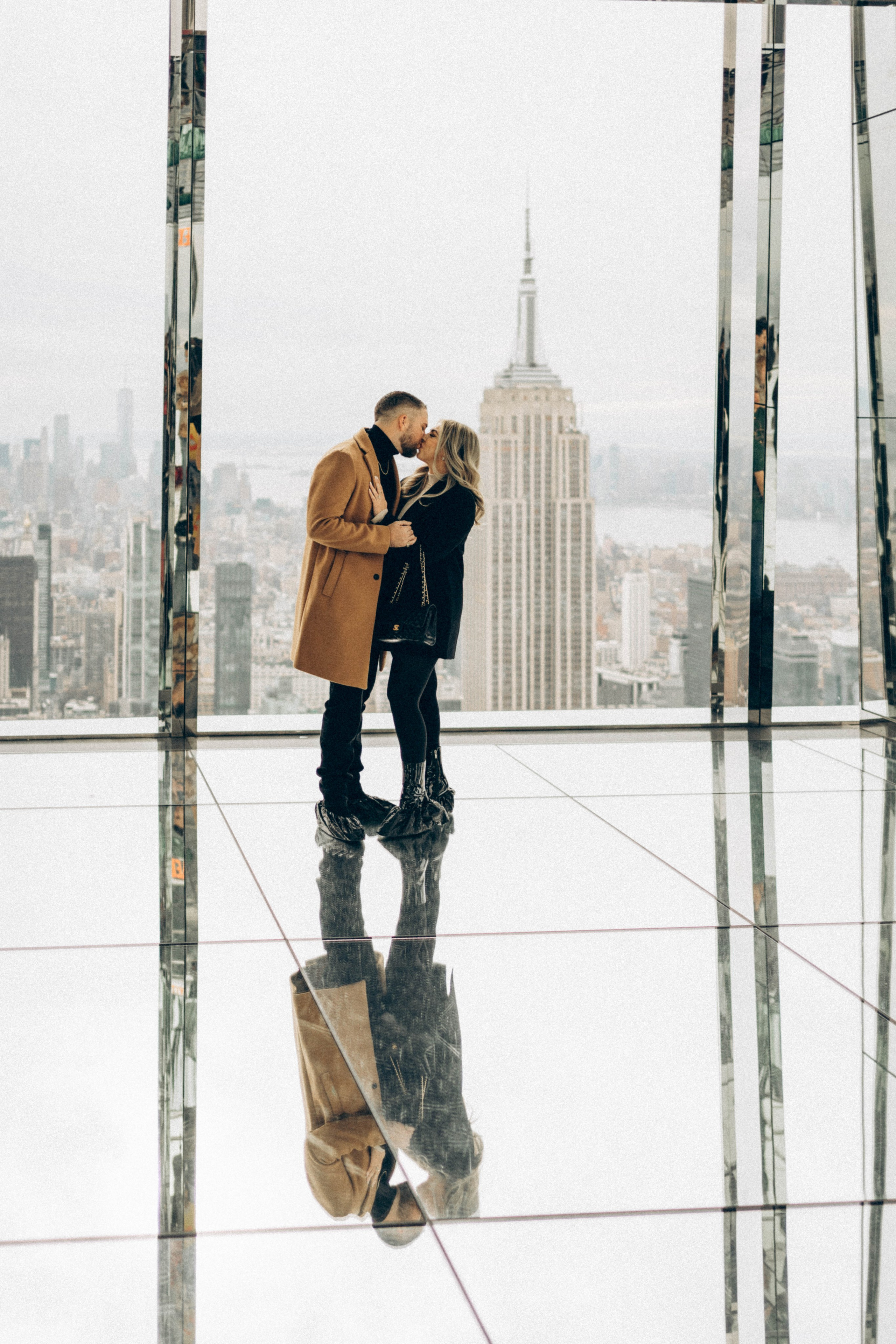 Man kneeling on Brooklyn Bridge with ring.