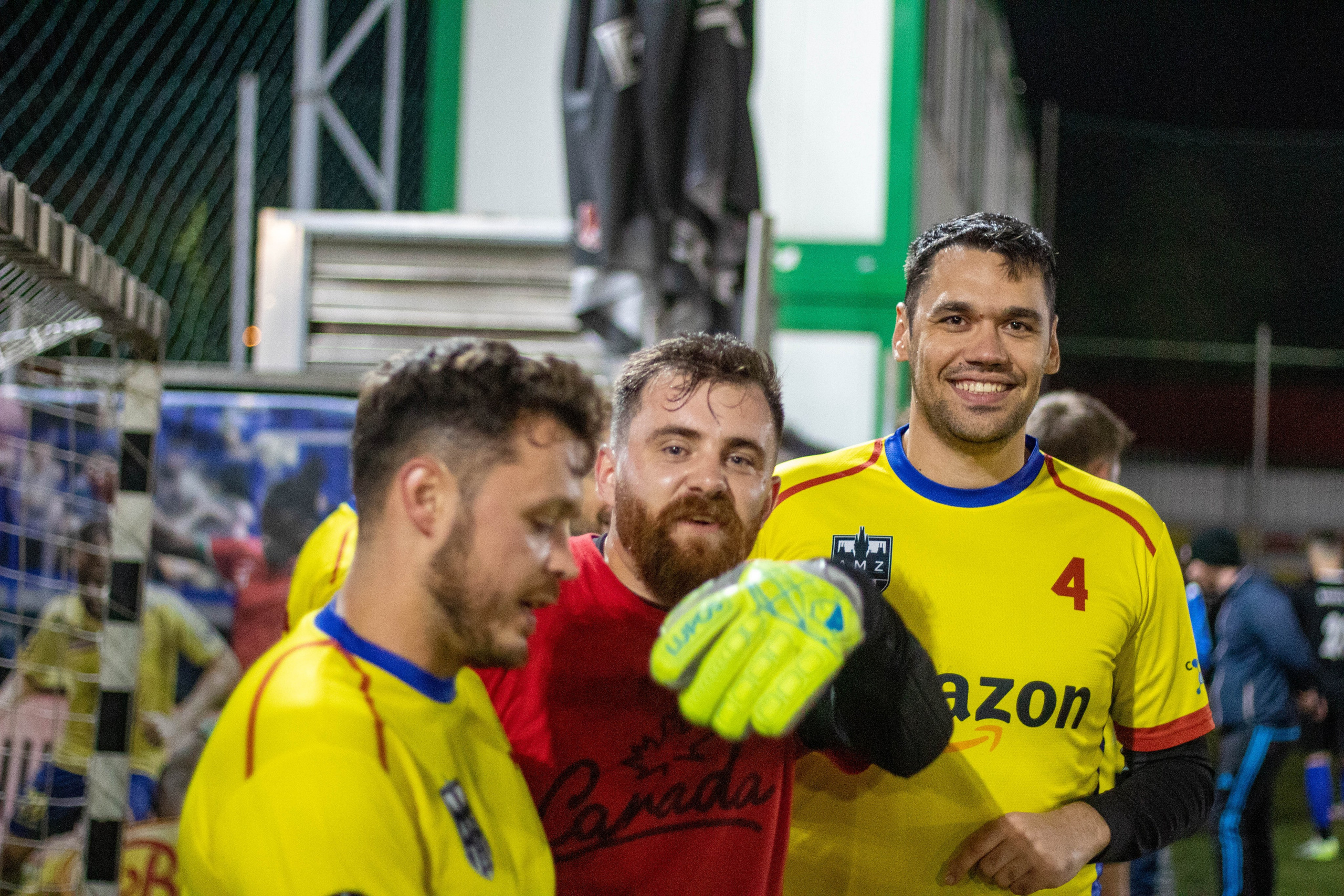 Football players in yellow jerseys smiling and talking after a match.