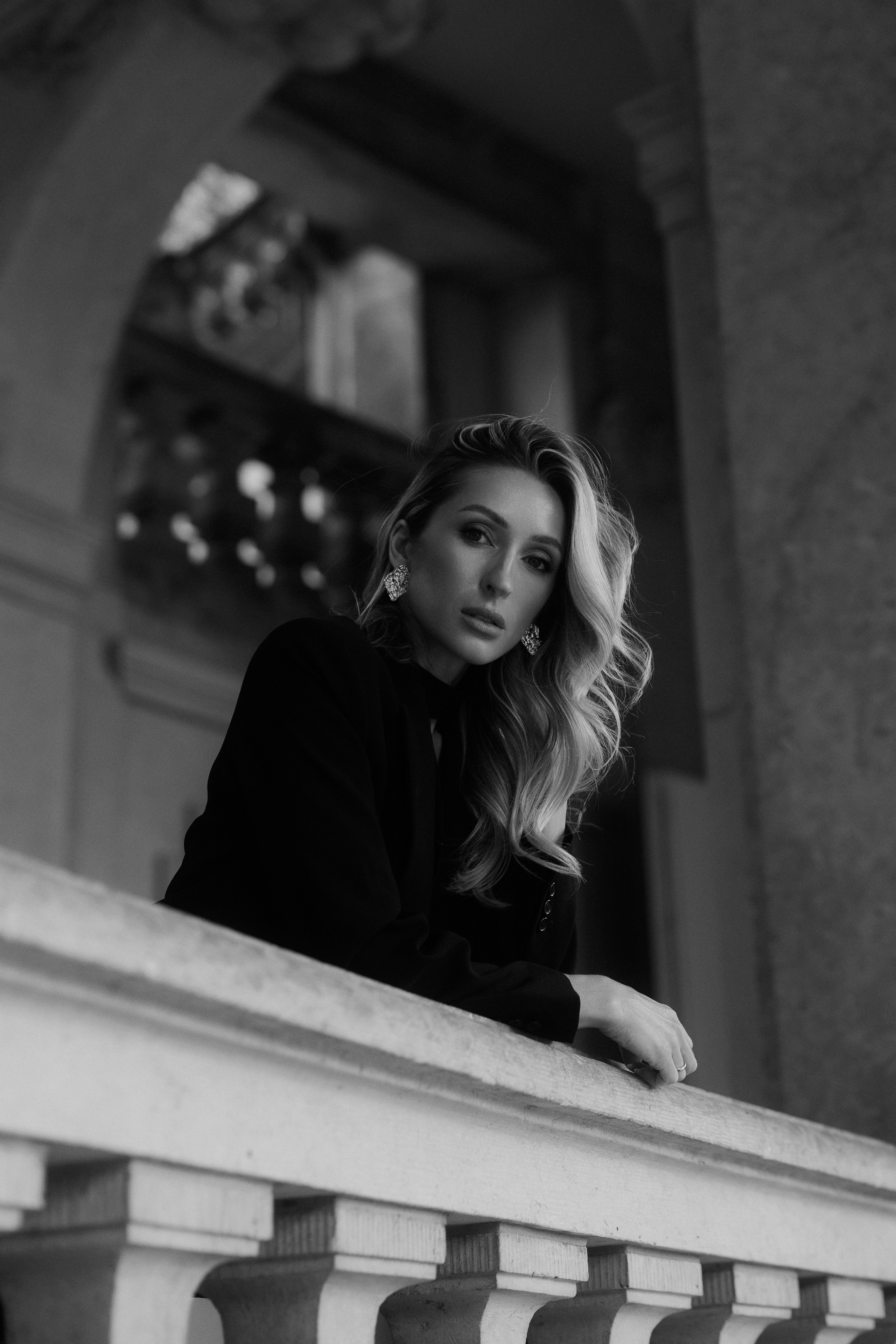 Moody black and white portrait of a stylish woman looking over a stone balcony in Dresden, Germany. Timeless editorial and female portrait photography available in Dresden, Leipzig and Wurzen. Атмосферный чёрно-белый портрет стильной девушки у каменной балюстрады в Дрездене, Германия. Вневременная редакционная и женская портретная фотография в Дрездене, Лейпциге и Вурцене.
