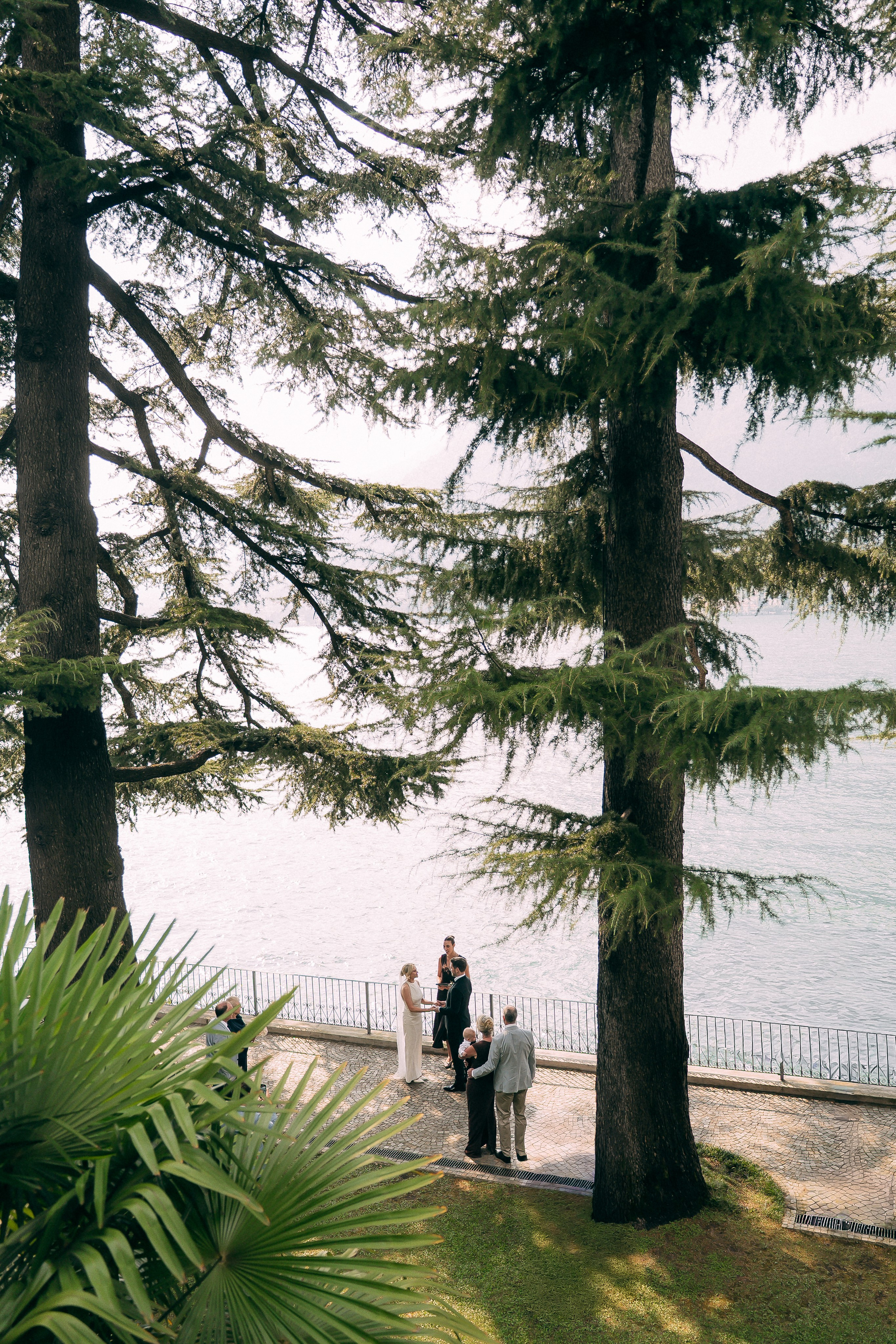 Scenic elopement portrait framed by trees at Villa Lario, Lake Como, Italy