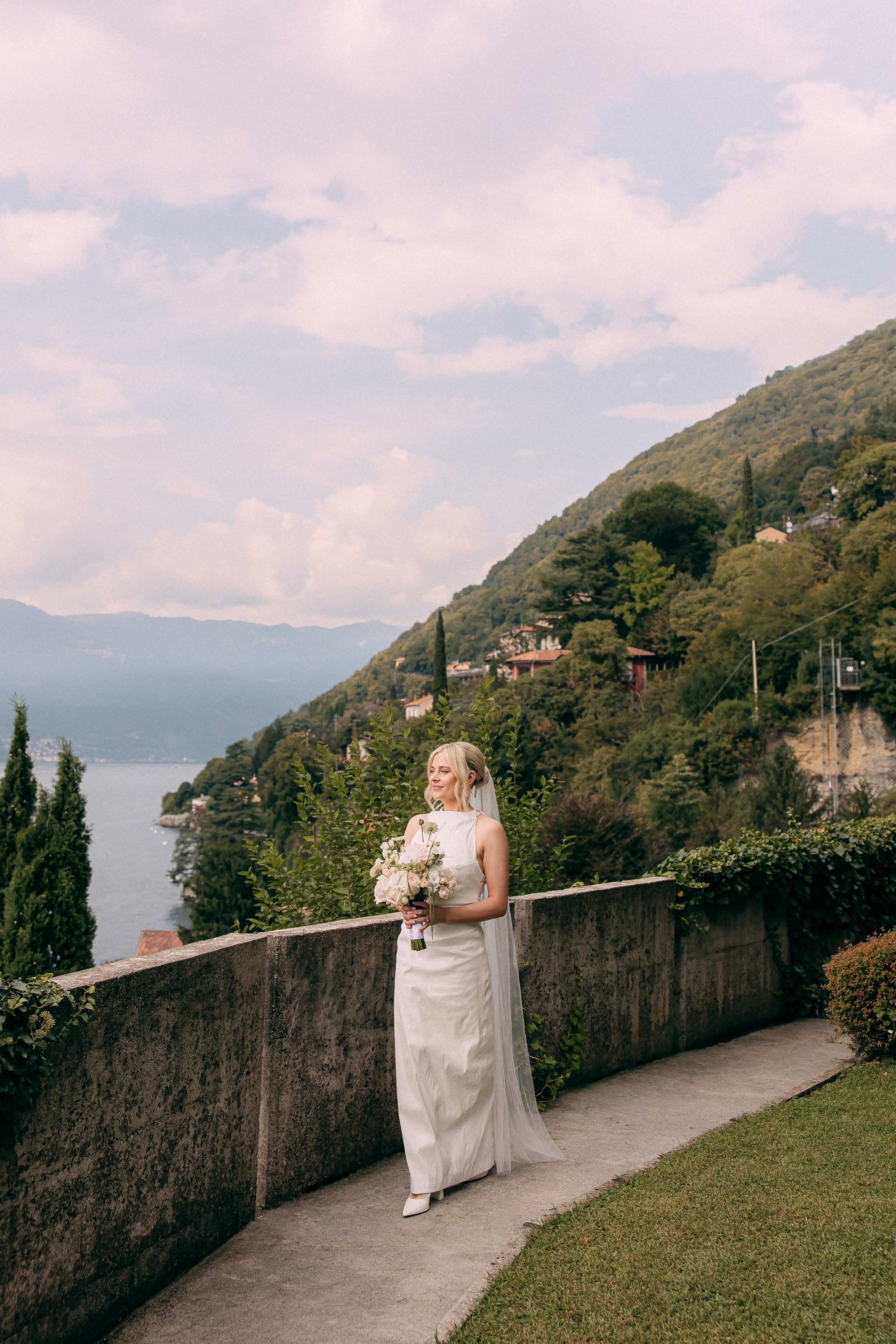 Bride standing on the terrace overlooking Lake Como at Villa Lario, Italy