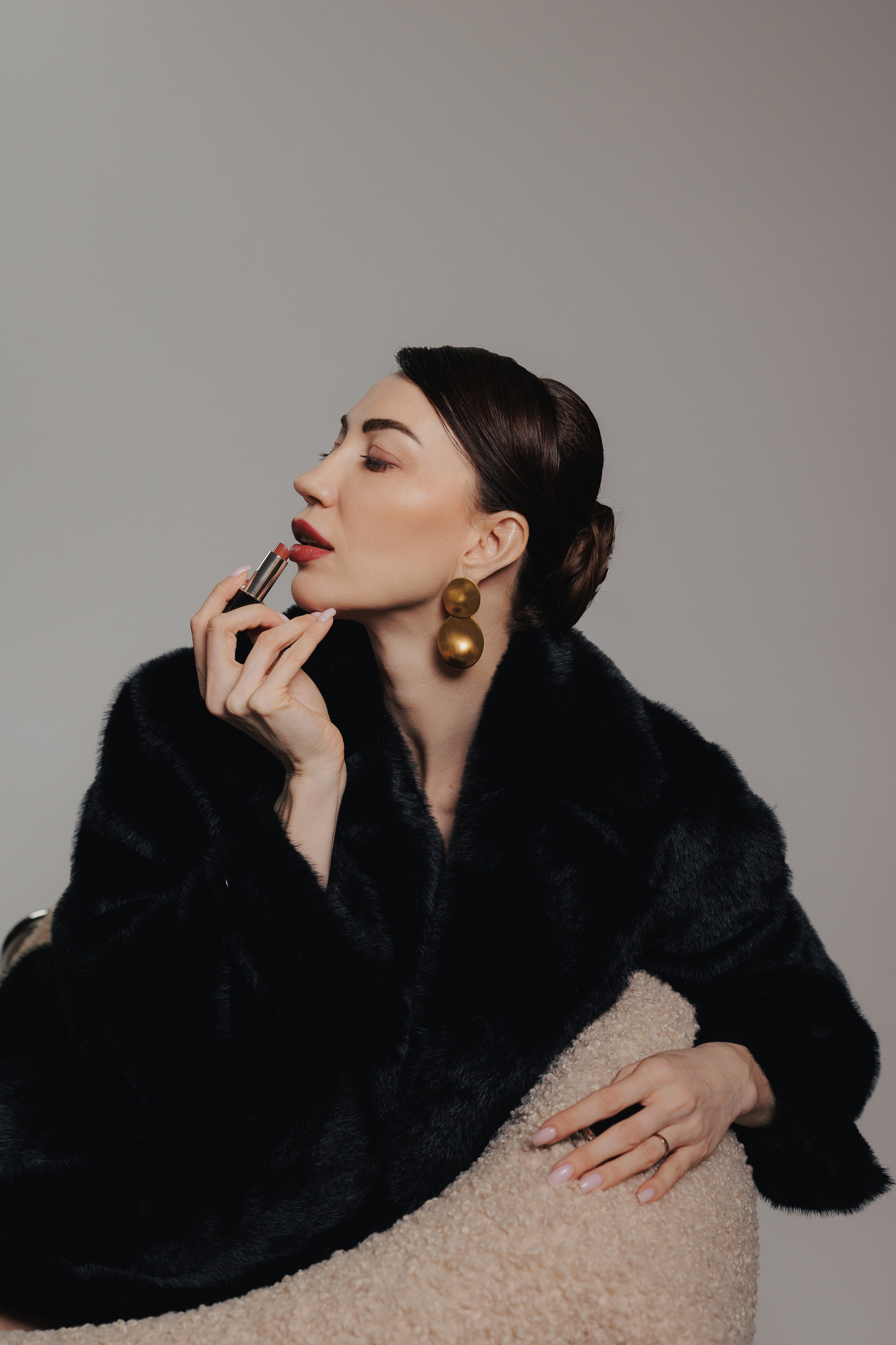 Artistic studio portrait of a woman in a black fur coat looking upward with expressive pose and soft dramatic light, photographed in Leipzig, Germany. Художественный студийный портрет девушки в чёрной шубе, смотрящей вверх в выразительной позе при мягком драматичном освещении, снятый в Лейпциге, Германия.