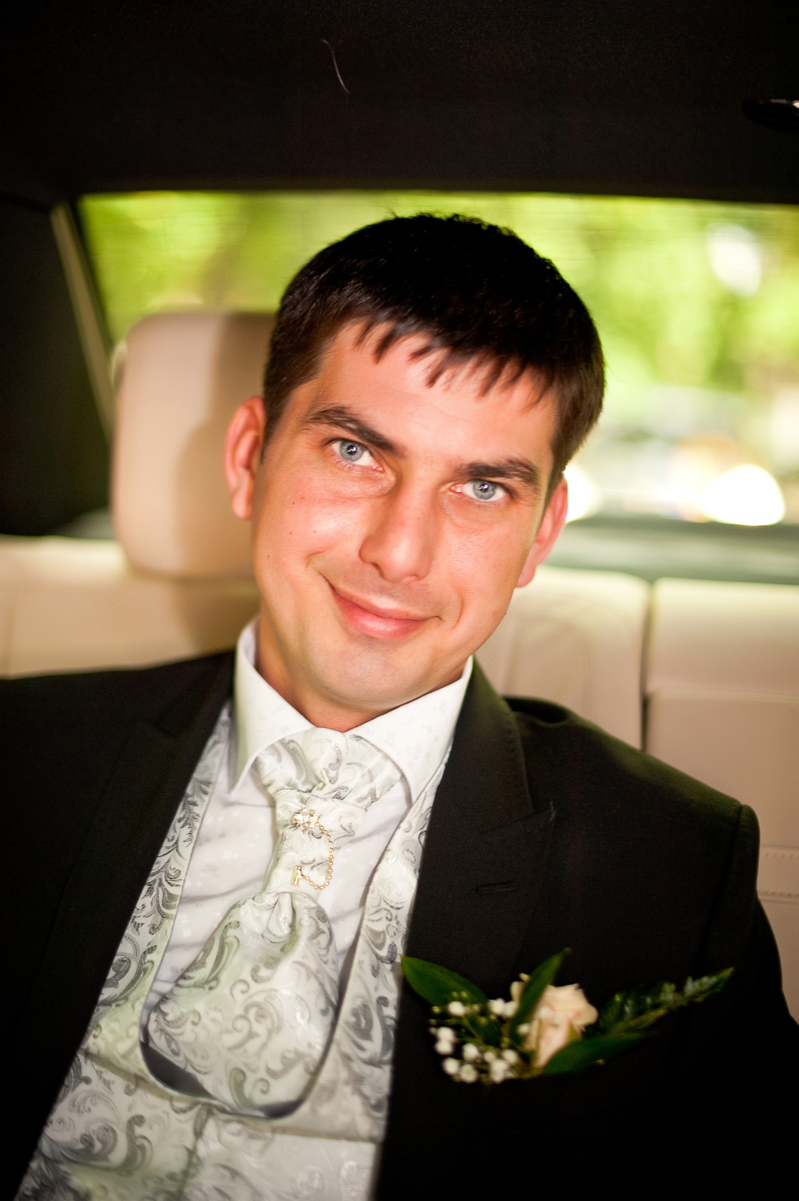 Свадебная фотосессия в Москве. Довольный жених сидит в свадебном автомобиле.