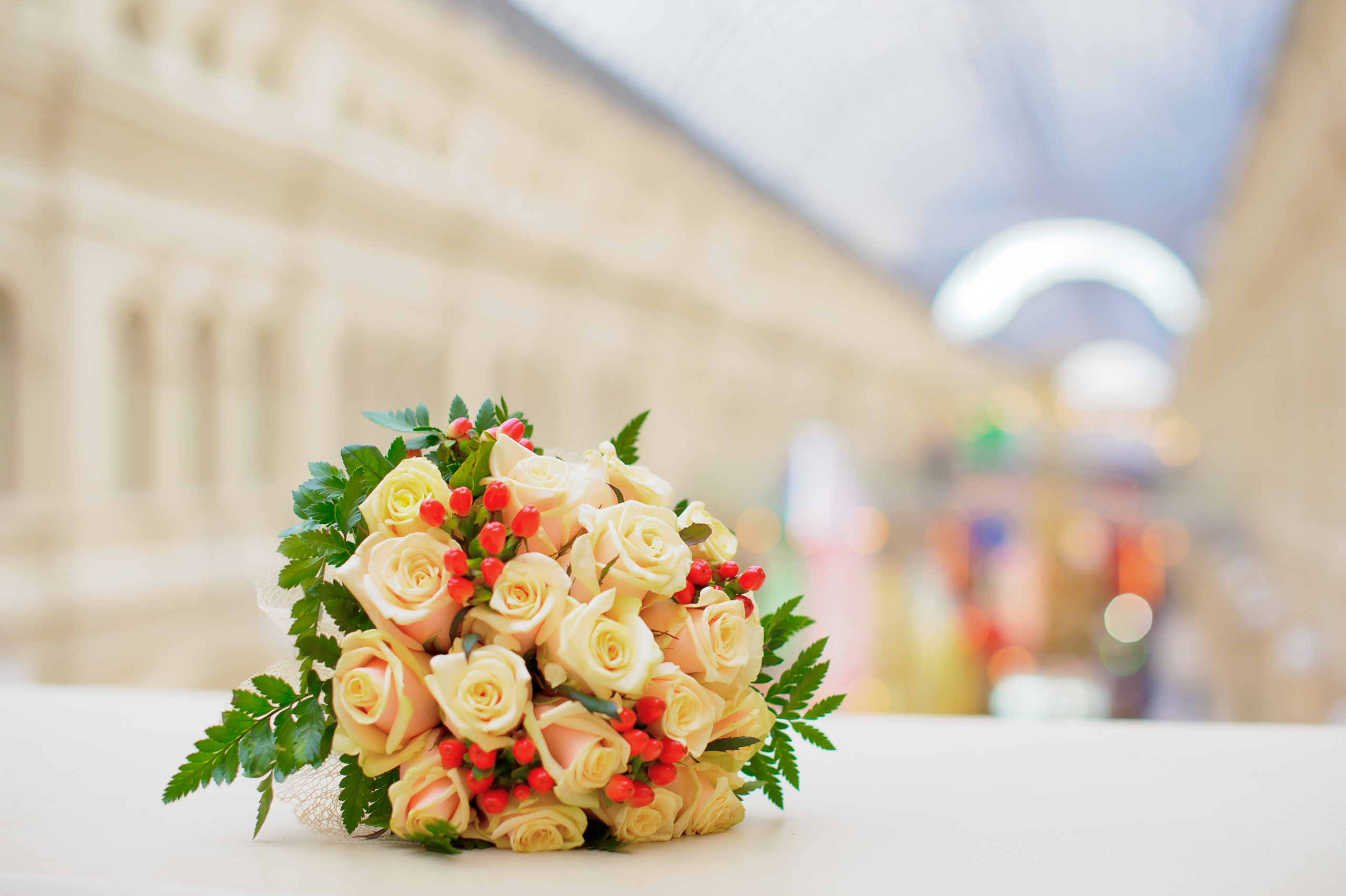 Свадебная фотосессия в Москве. Свадебный букет из чайных и красных роз лежит на перилах