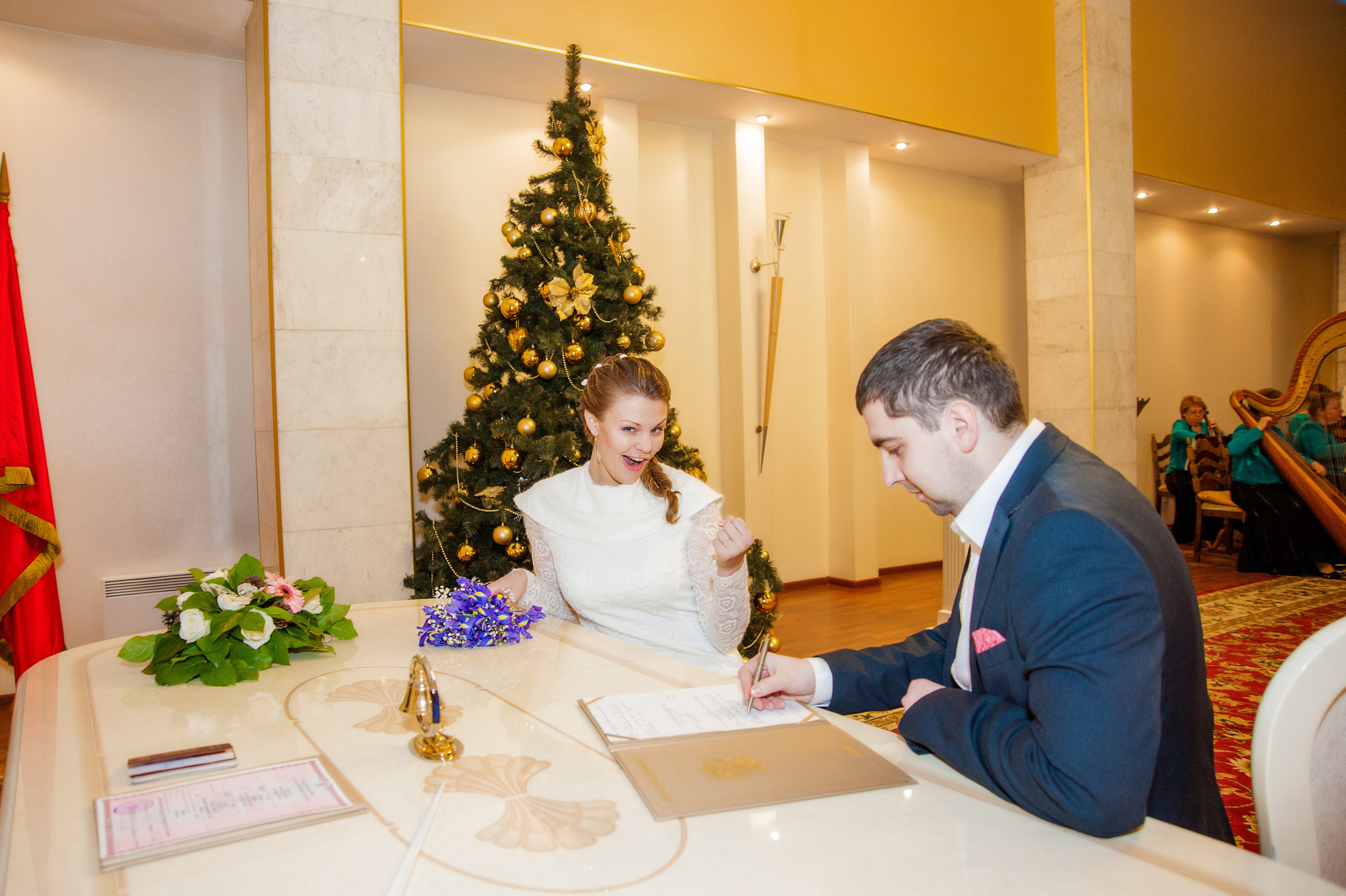 Свадебная фотосессия в Москве. Дворец Бракосочетания №4 регистрация брака. Невеста радуется когда жених ставит подпись.