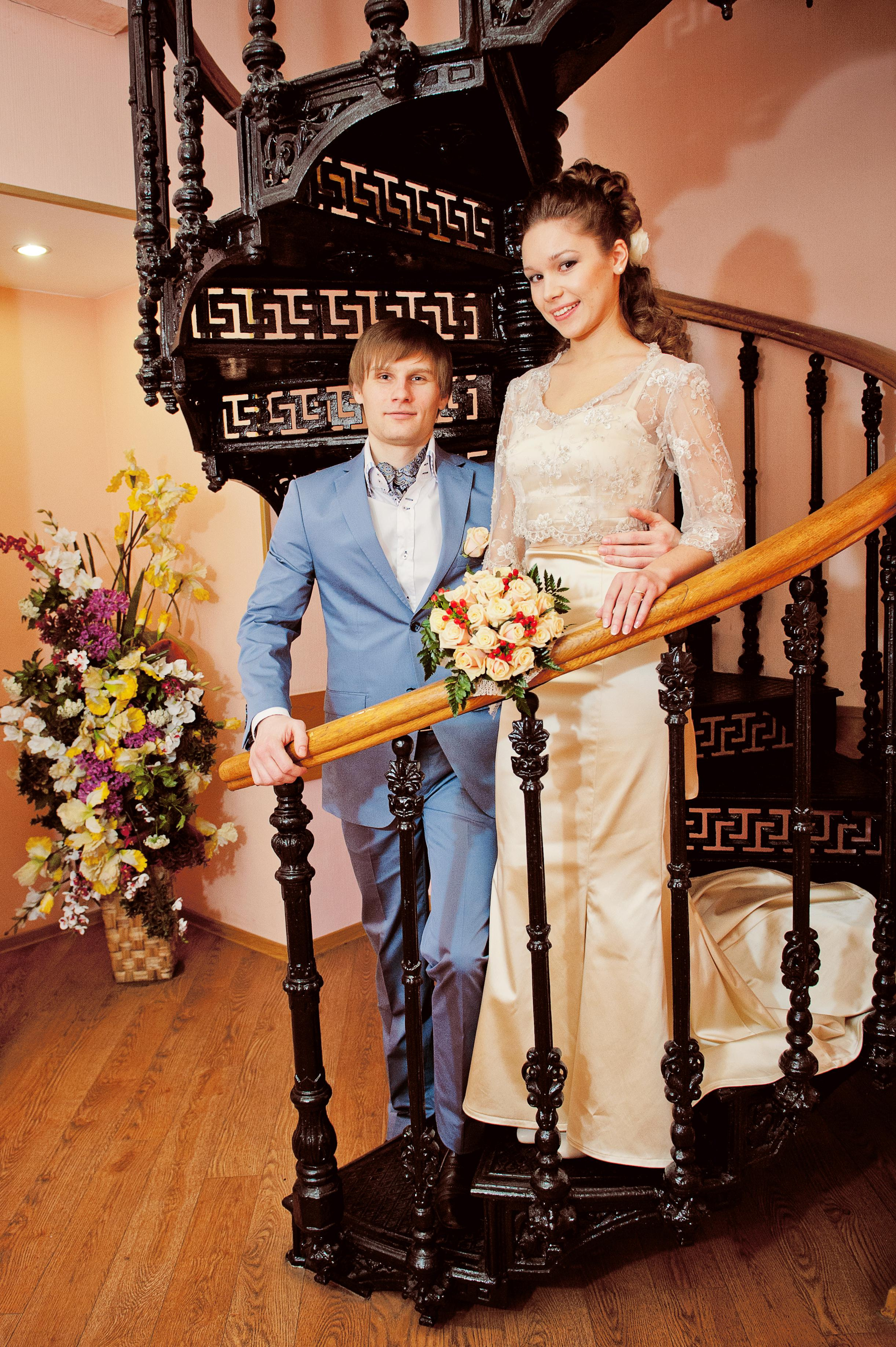 Свадебная фотосессия в Москве. Жених и невеста стоят на винтовой кованной лестнице в Мещанском ЗАГСе.