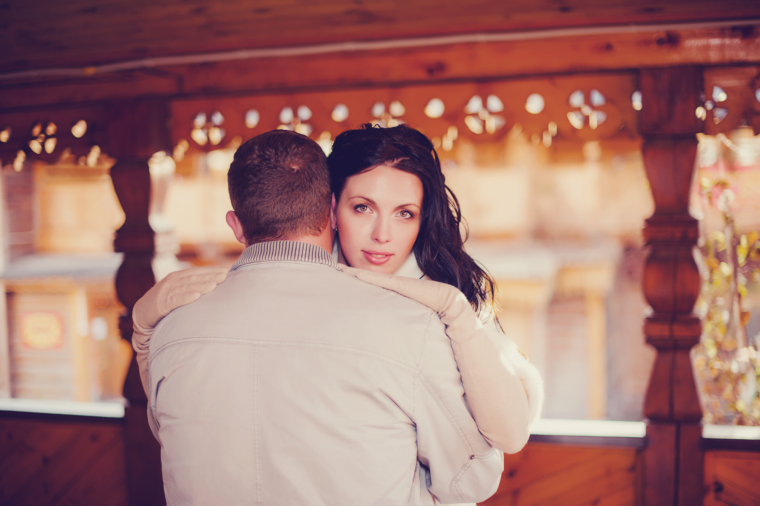 Свадебная фотосессия в Москве. Невеста обнимает жениха на деревянном мосту