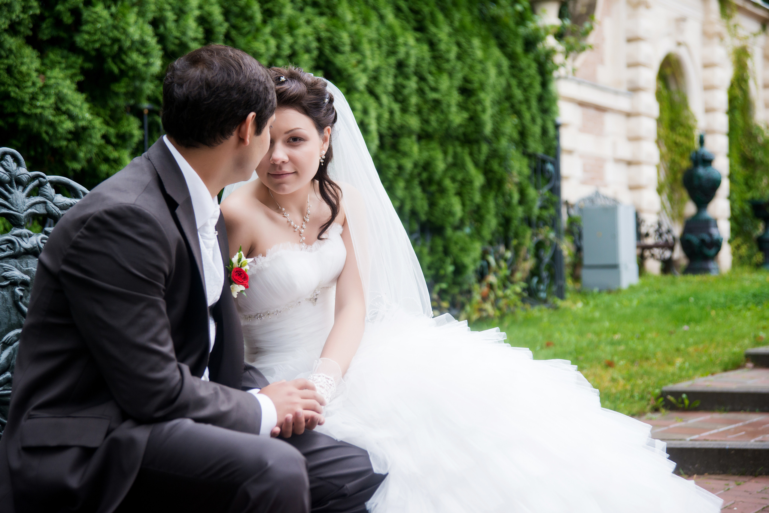 Свадебная фотосессия в Москве. Жених с невестой сидят на скамейке. Невеста выглядывает из-за спины жениха