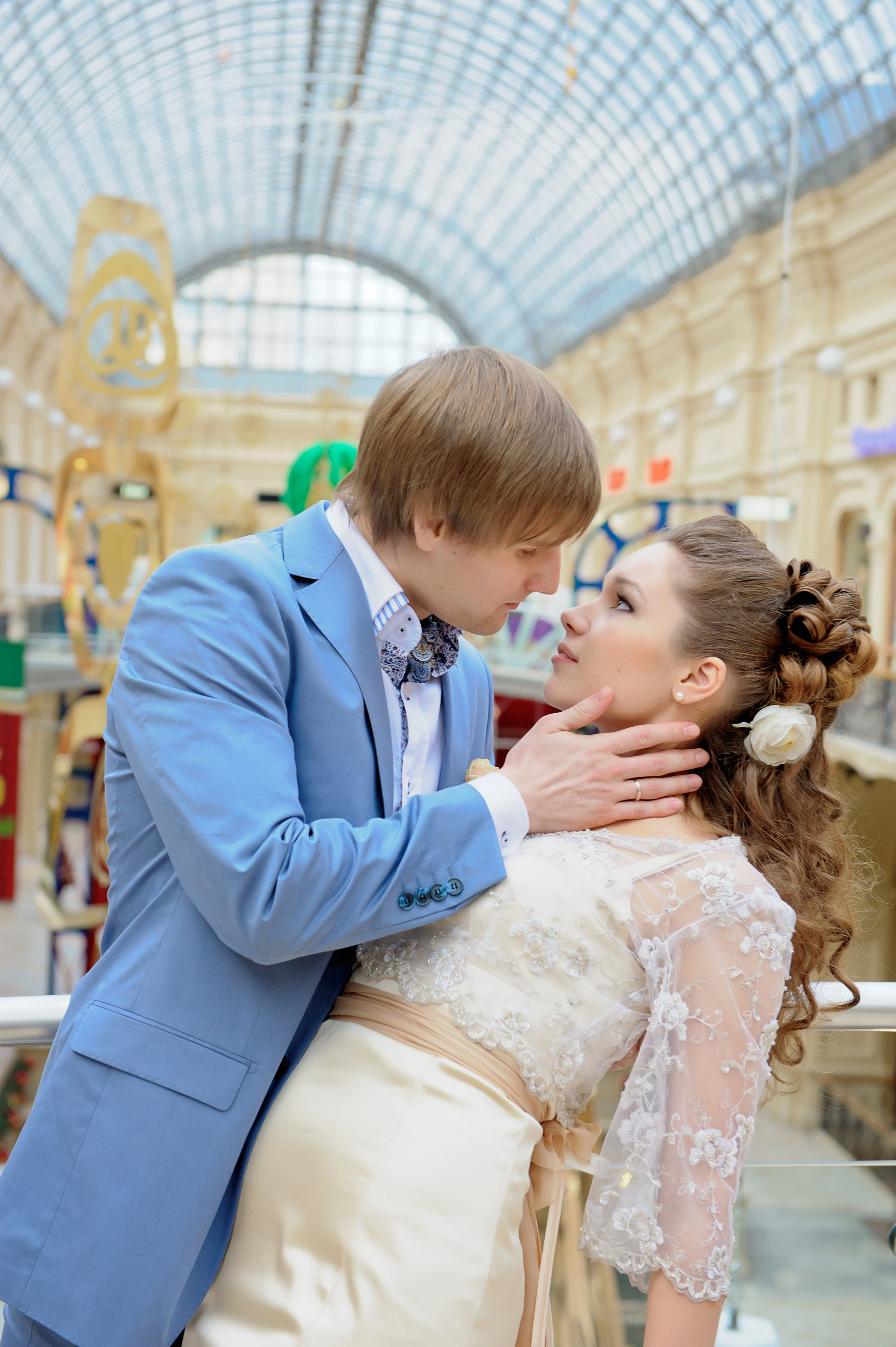 Свадебная фотосессия в Москве в Гуме Цуме. Жених целует невесту.