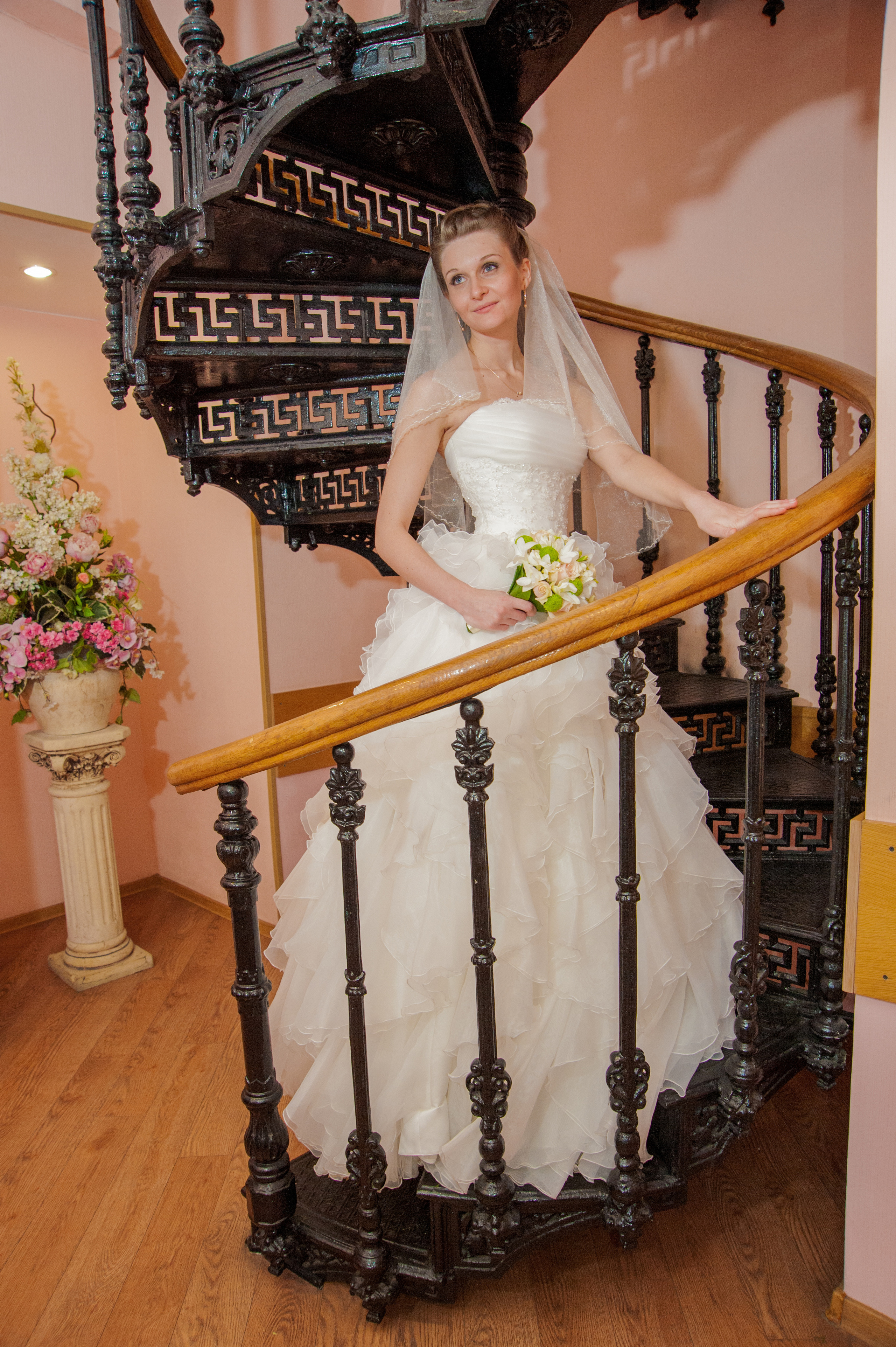 Свадебная фотосессия в Москве. Невеста стоит на кованной винтовой лестнице в Мещанском ЗАГСе Москвы.