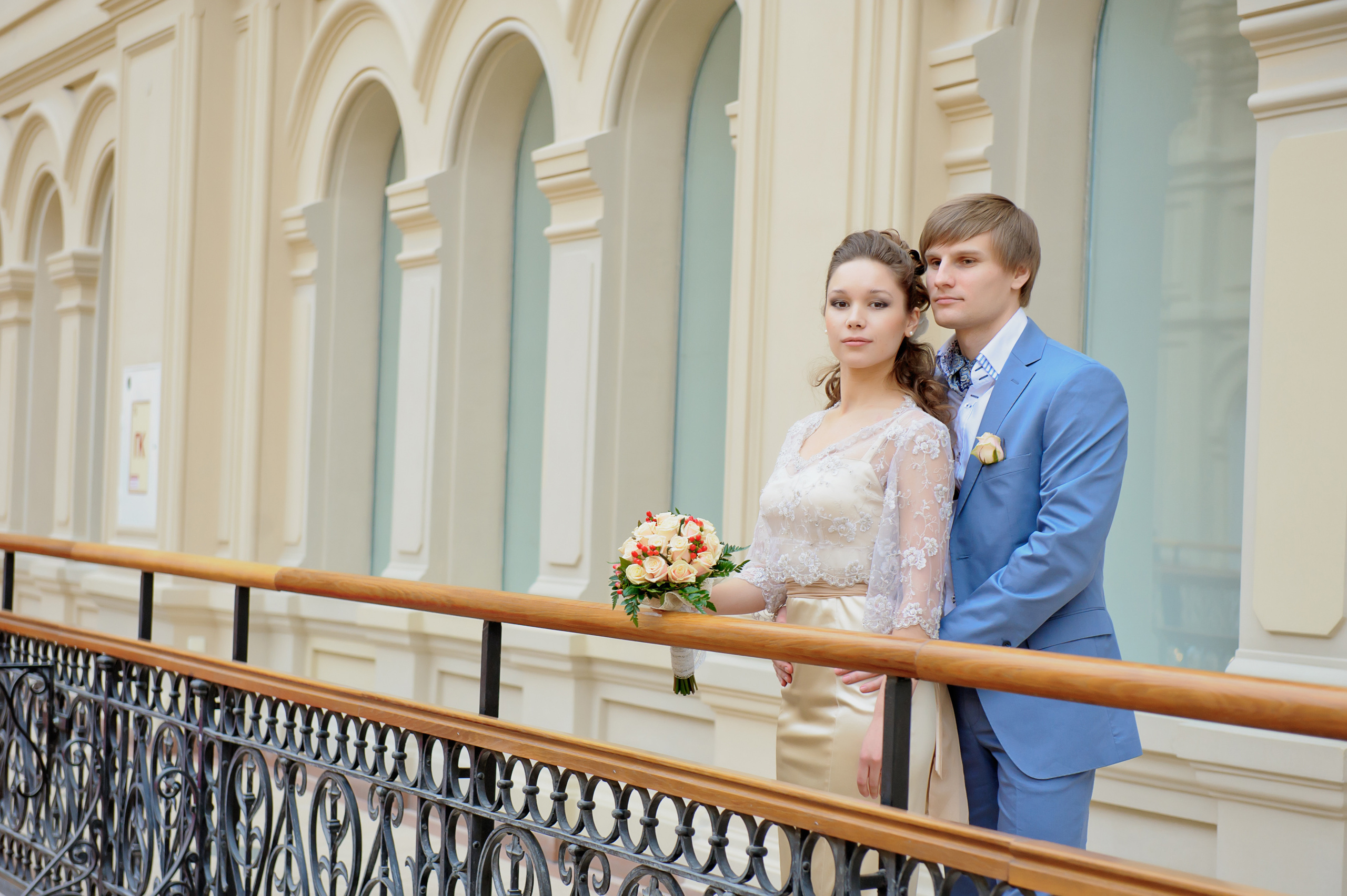 Свадебная фотосессия в Москве в Гуме Цуме. Жених обнимает невесту на мосту.