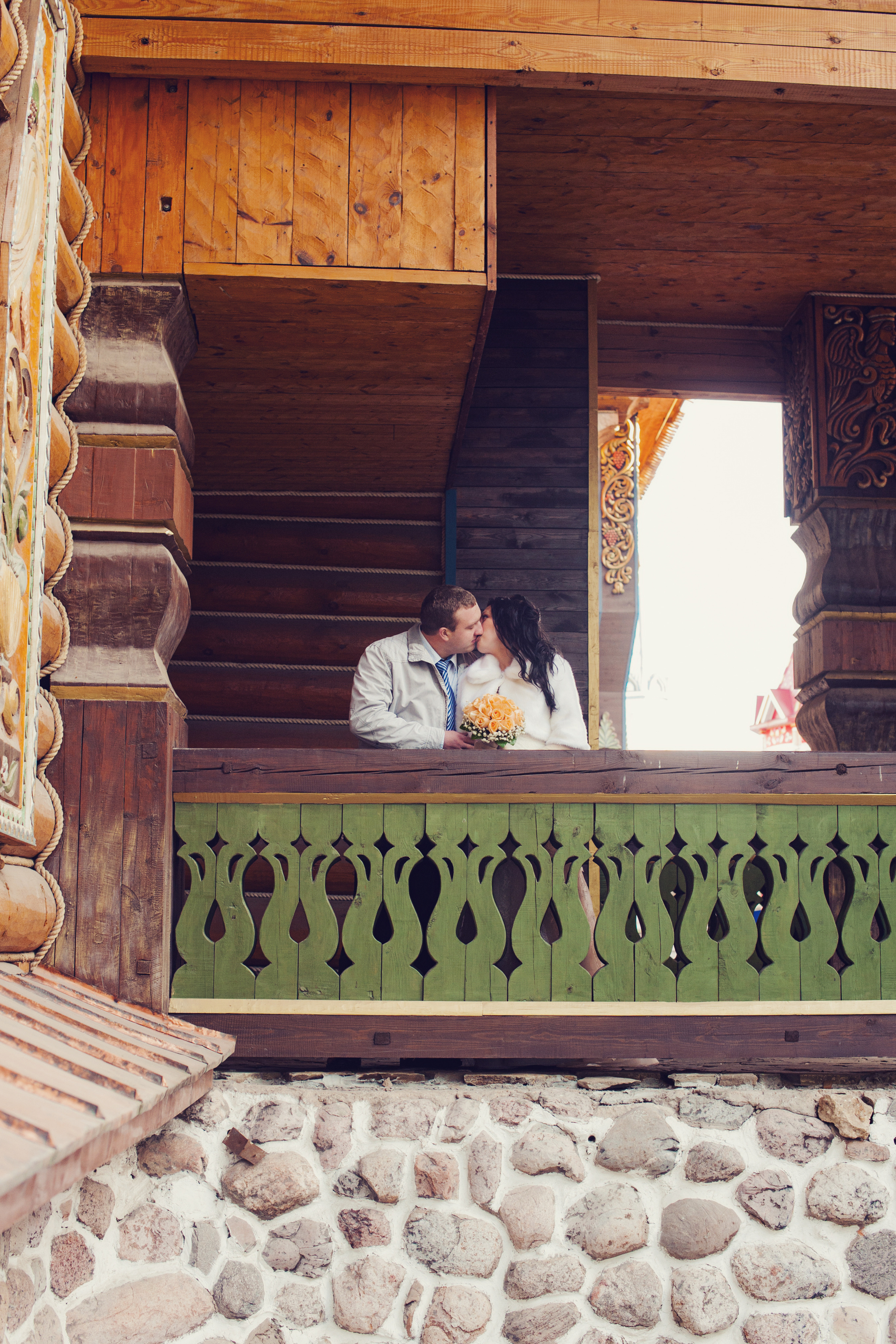 Свадебная фотосессия в Москве. Невеста обнимает жениха на деревянном мосту