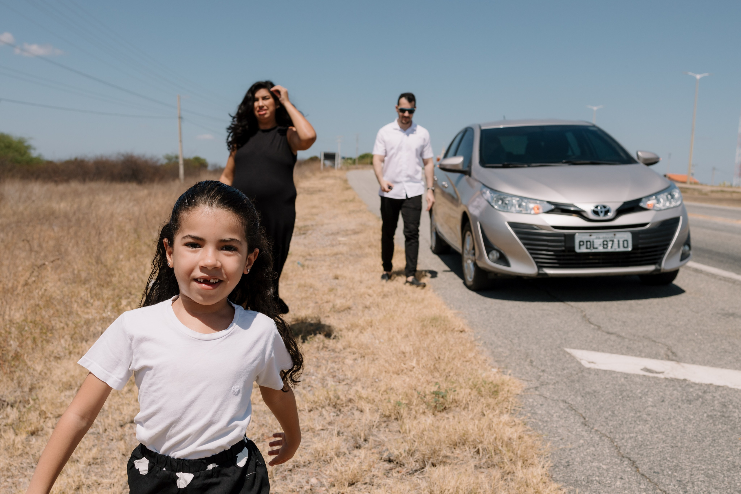Família caminhando na beira da estrada em ensaio fotográfico 