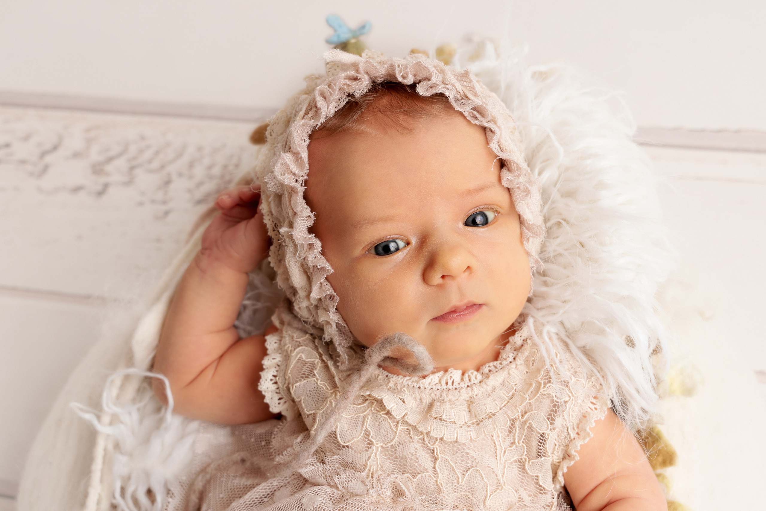 Neugeborenes Mädchen schaut  mit blauen Augen in die Kamera