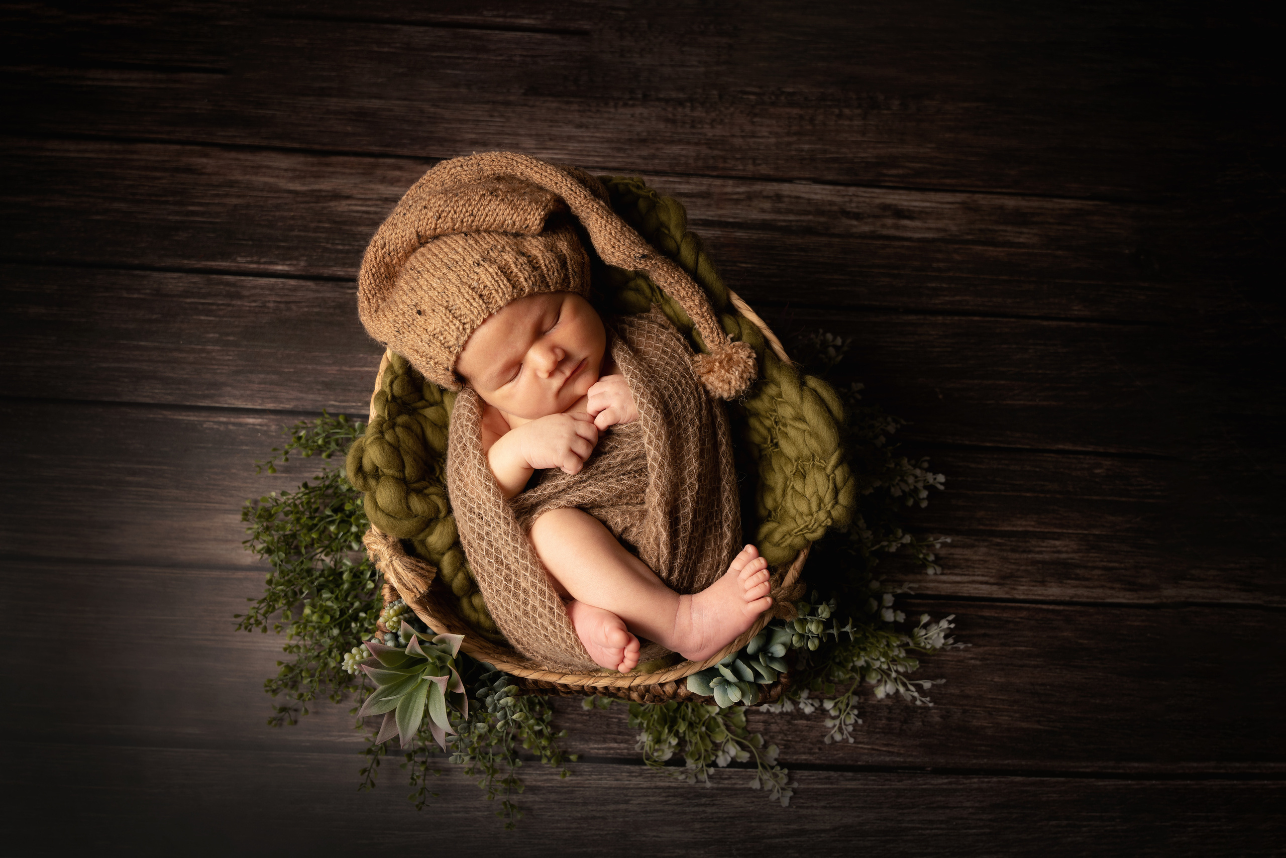 Baby mit Gnomenhut zwischen Kakteen