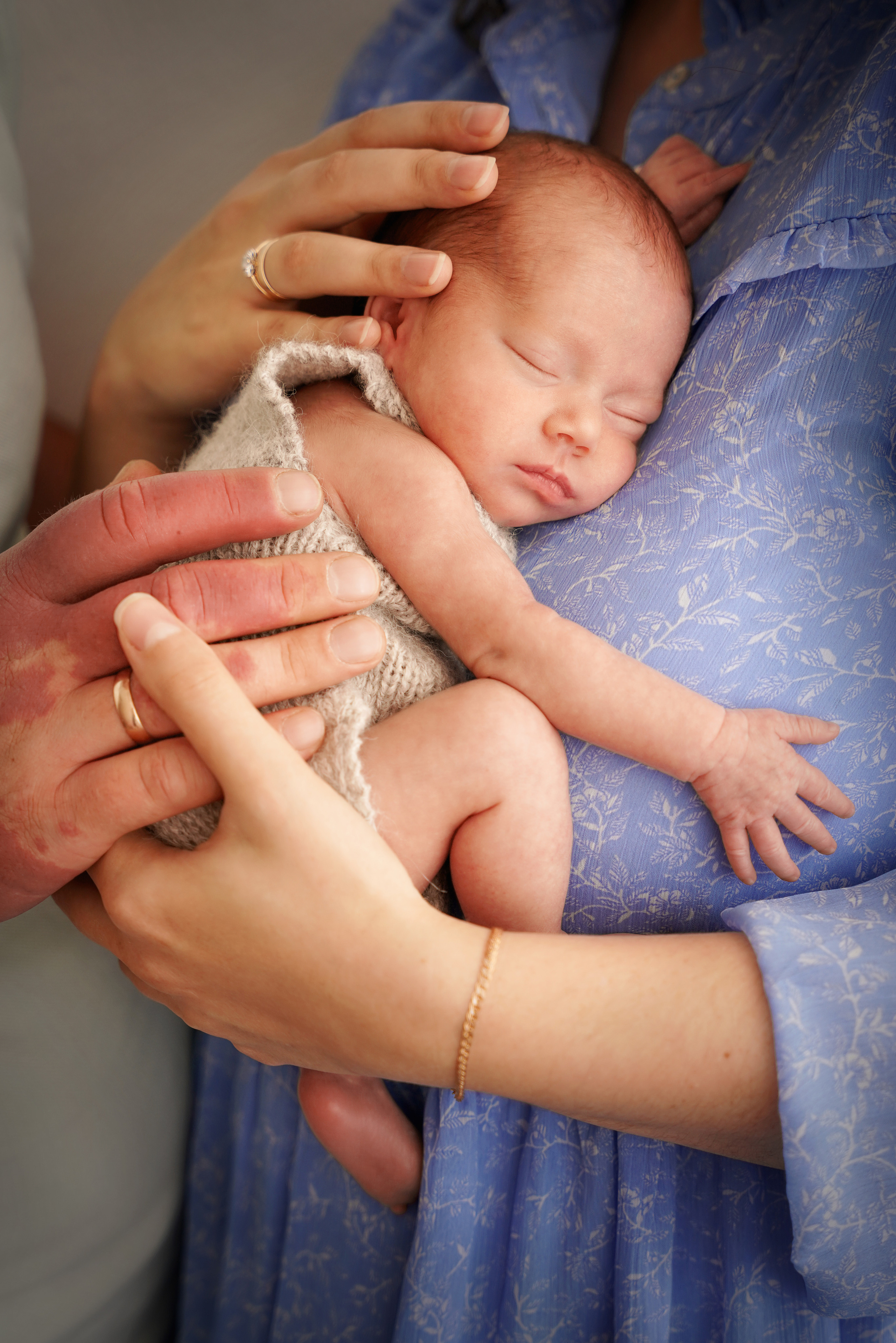 Baby schläft beim Fotoshooting auf Mamas Brust