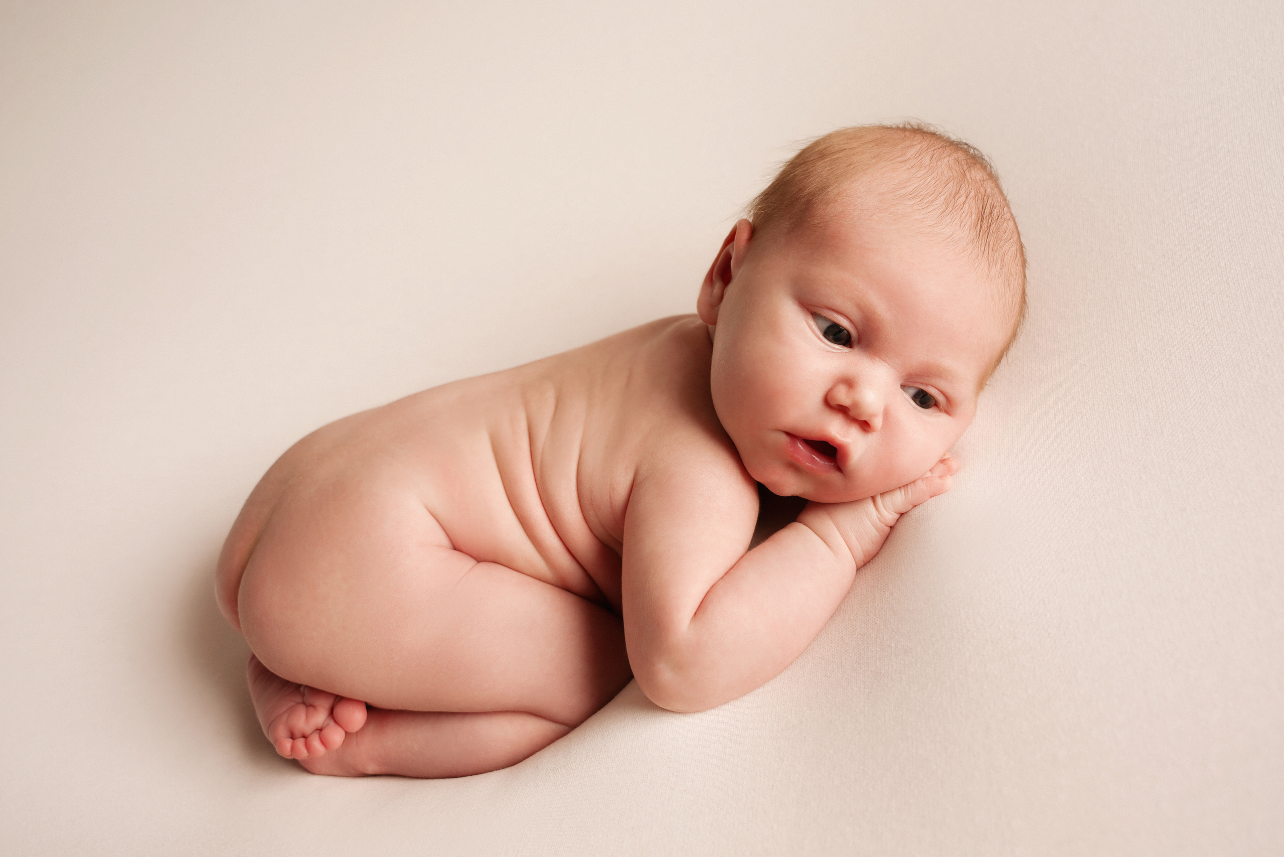 Ein neugieriges Baby schaut neugierig in die Welt. Neugeborenenfotografin und Retoucher in Augsburg Nastassia Schneider
