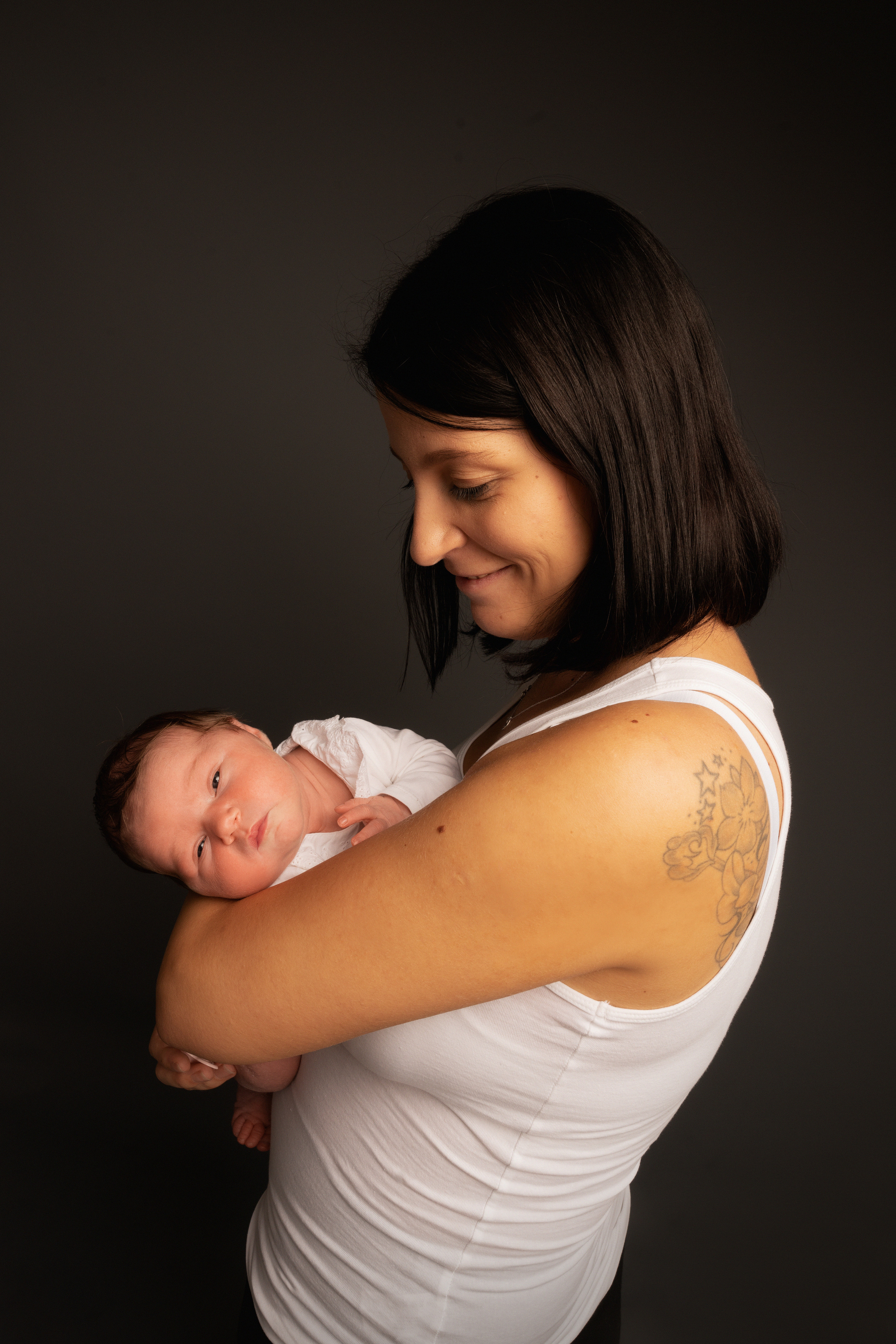 Neugeborenes schaut über die Schulter der Mutter schaut