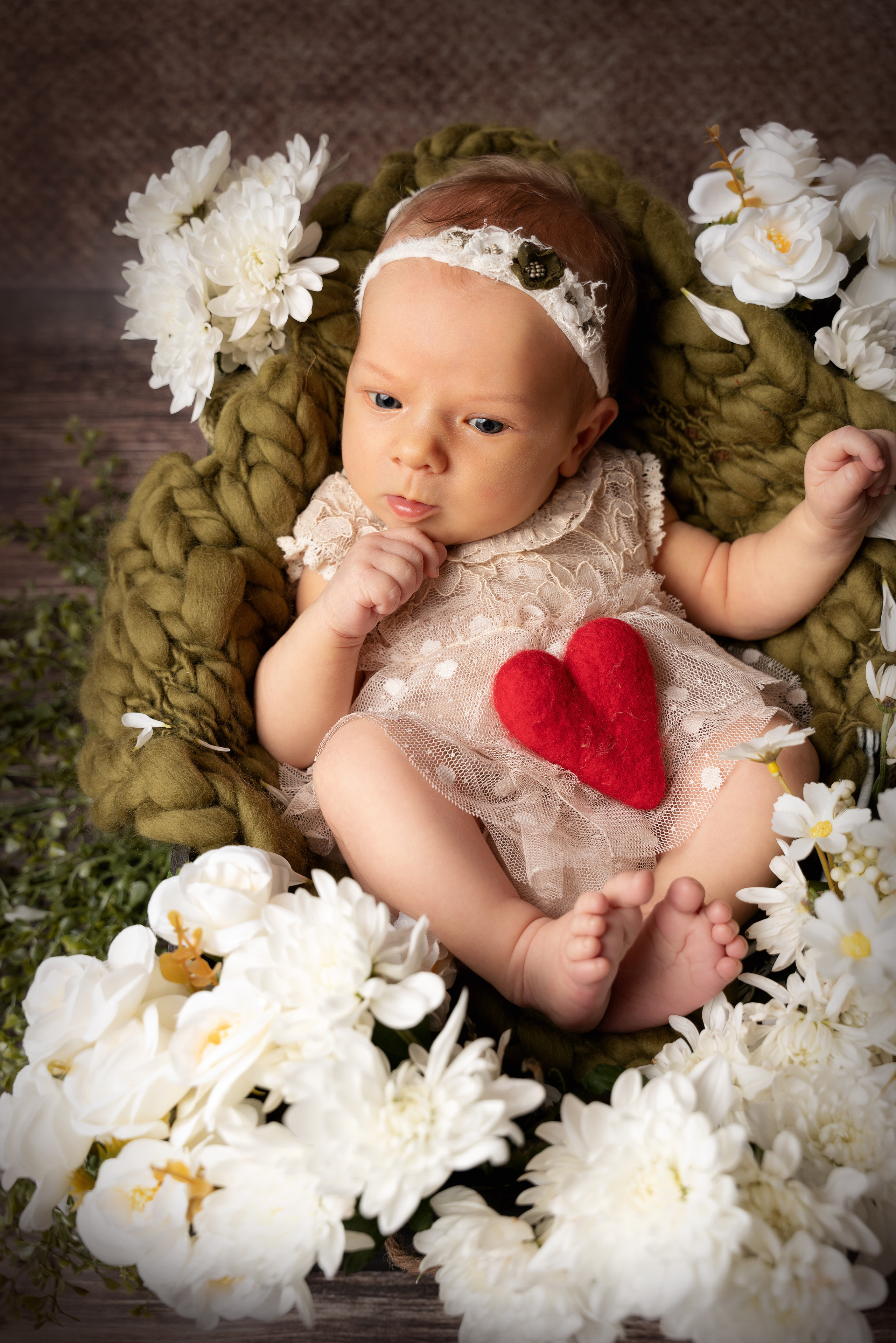Neugeborenes Mädchen liegt in weißen Chrysanthemen