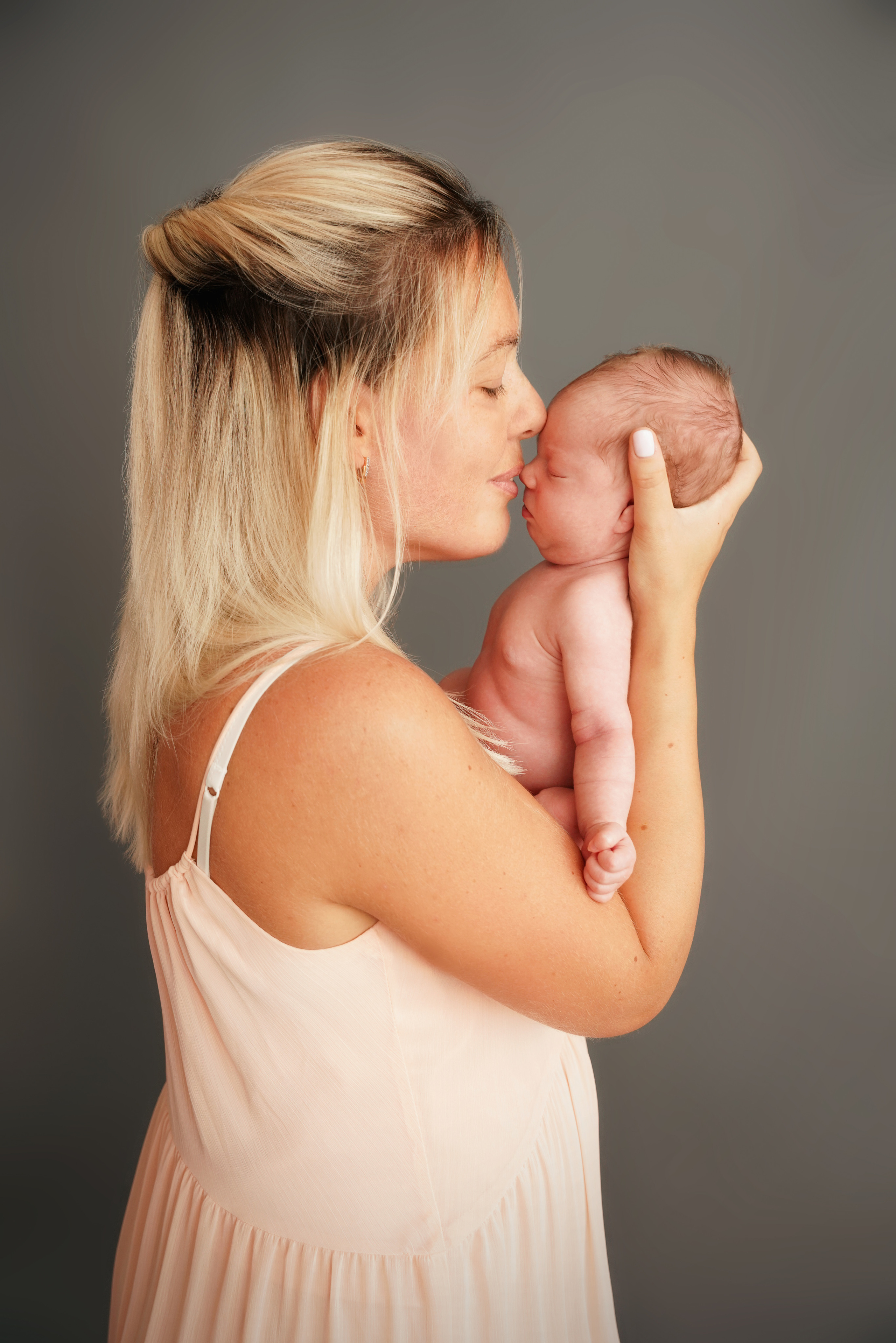 pfirsichfarbenes Kleid an einer Mutter, die ihre Tochter küsst