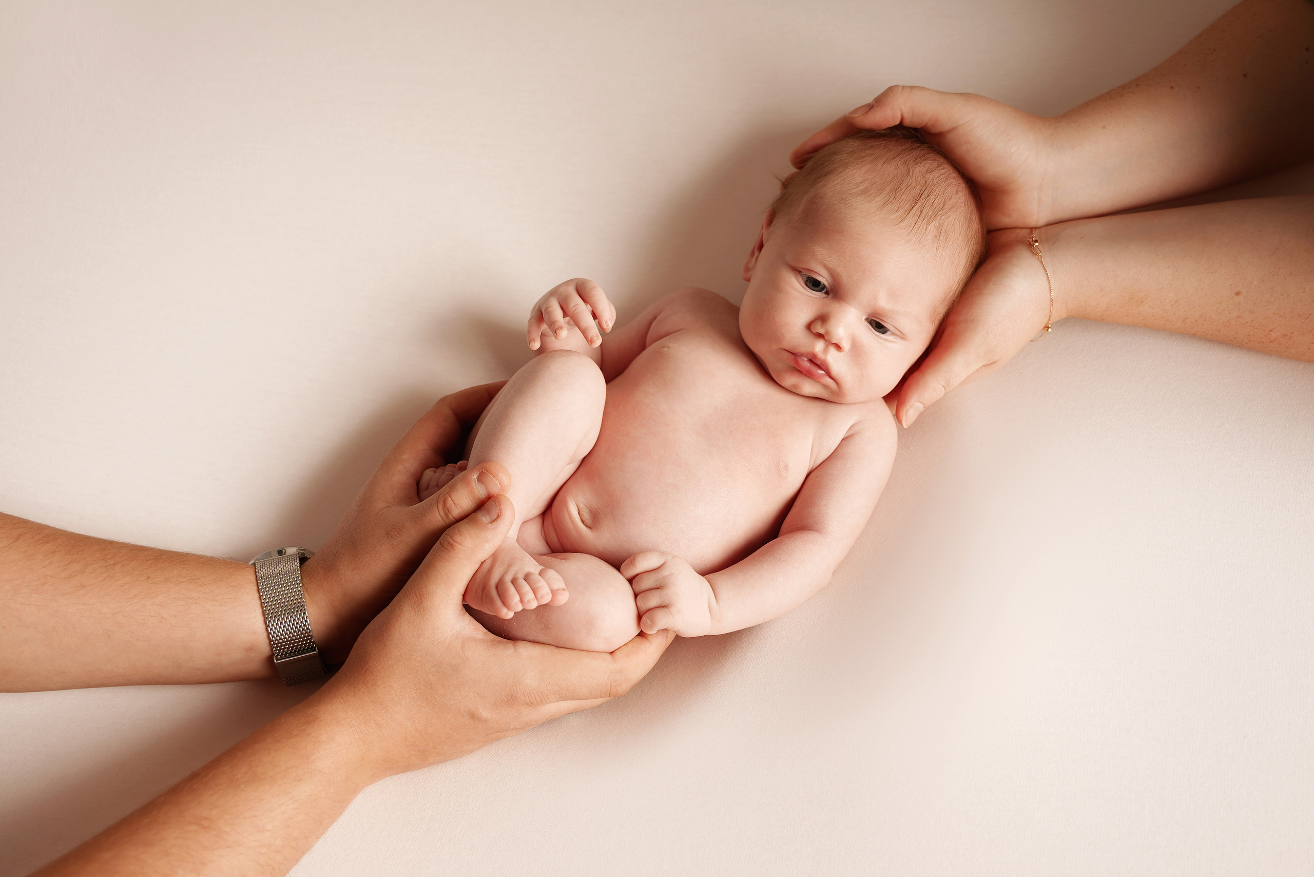 Das nackte Baby blähte seine Wangen auf und zeigte seine Zunge