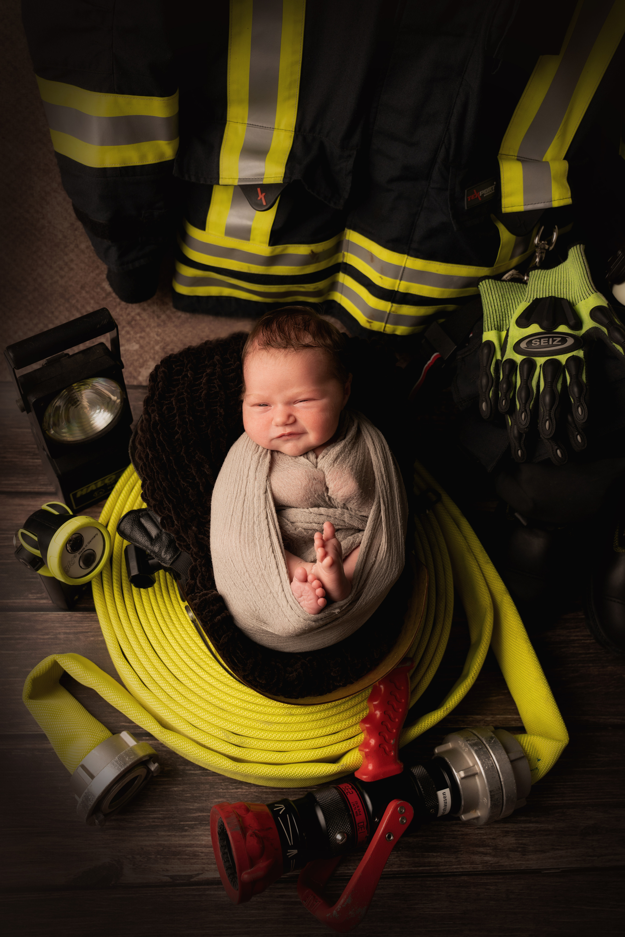 zwischen den Feuerwehrgeräten schläft die Tochter von Feuerwehrleuten