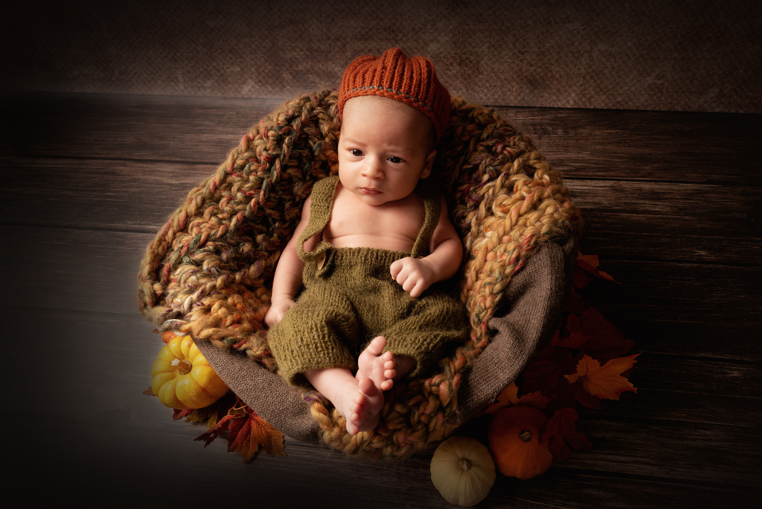 Baby in einem Hut, der wie ein Kürbis aussieht