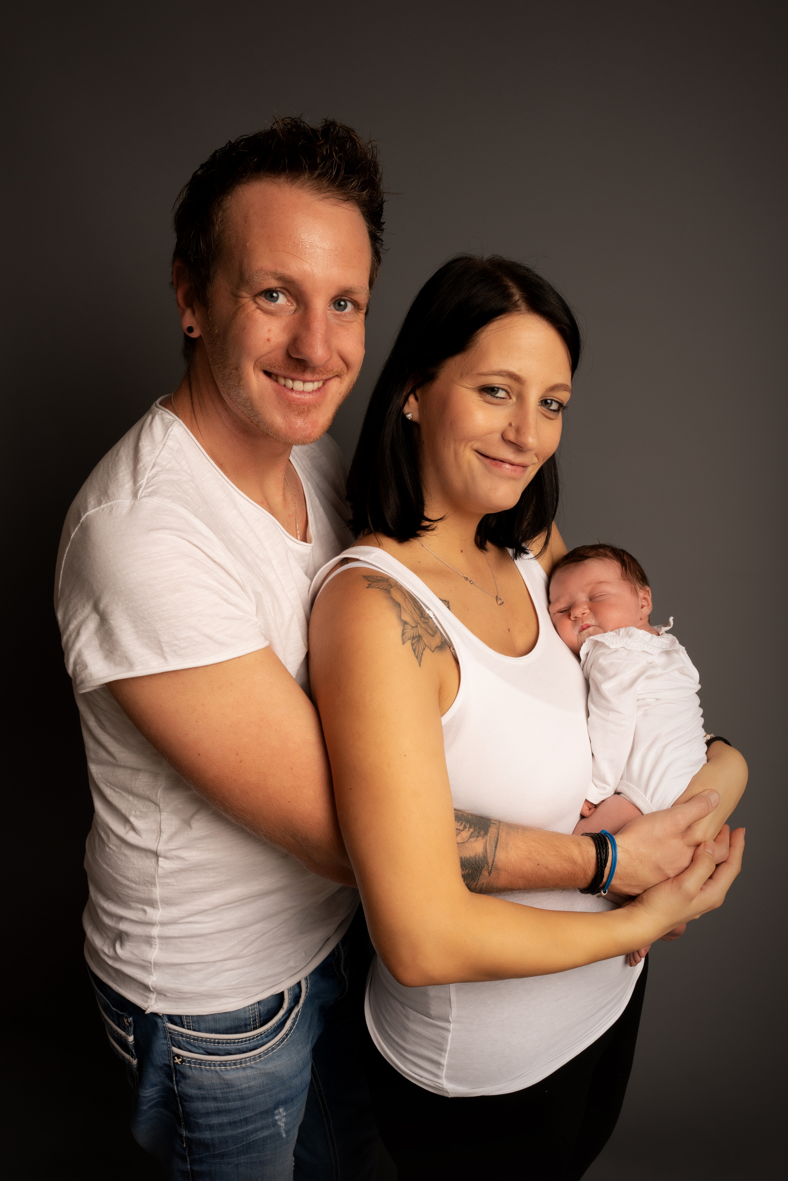 Das Baby ist von seinen Eltern umgeben und fühlt sich geborgen