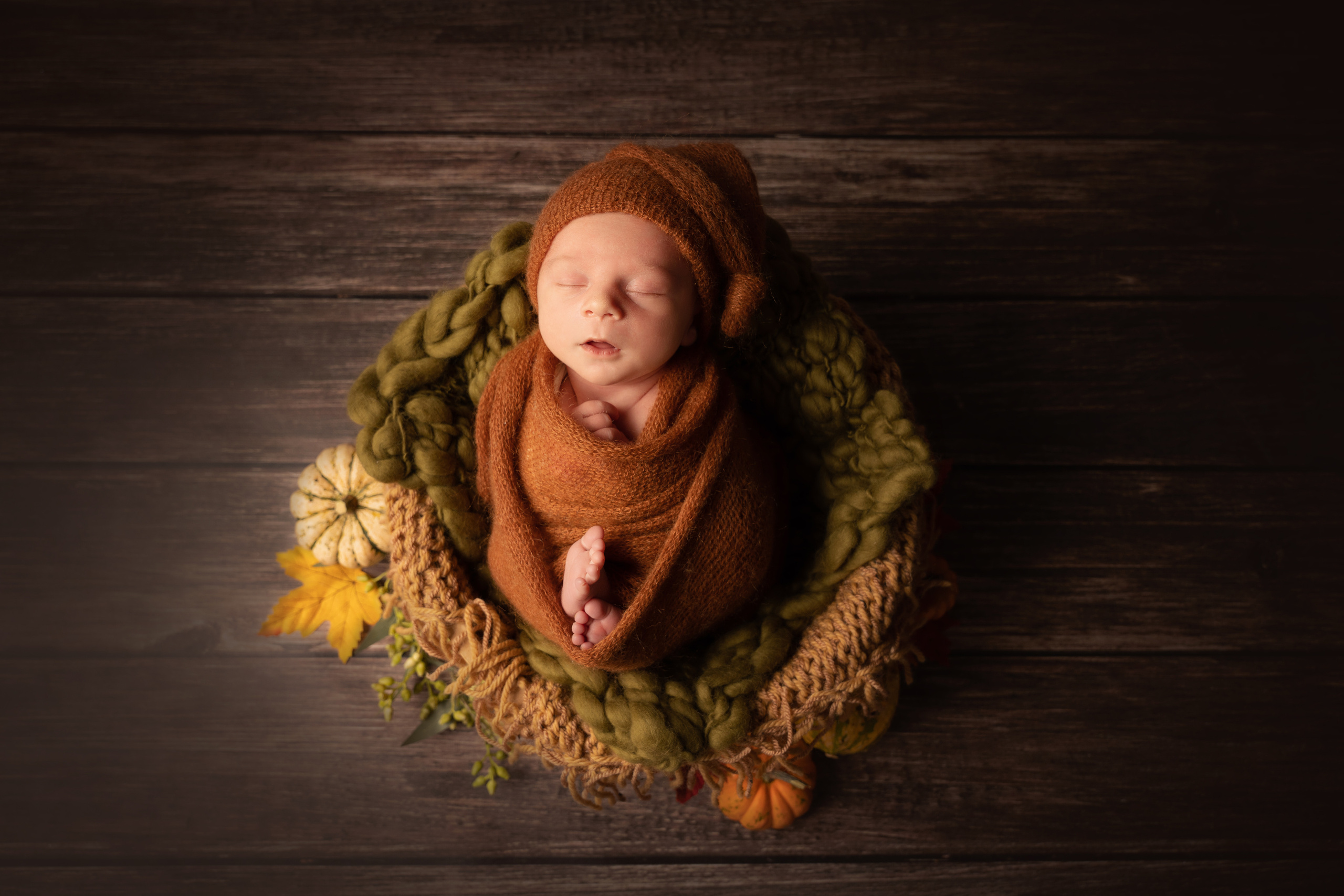 Foto von Baby unter Kürbissen