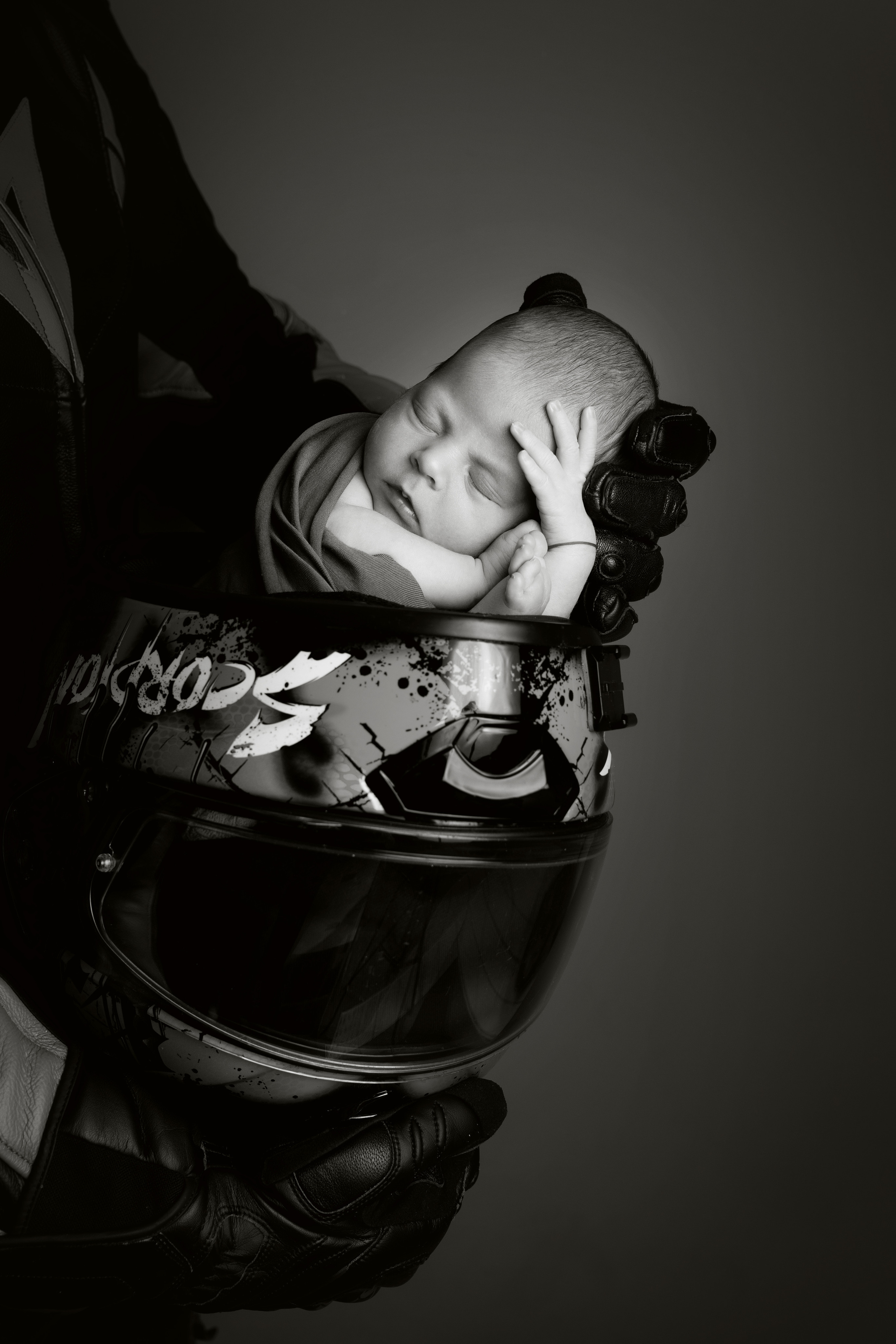 Schwarz-Weiß-Foto eines Babys Im  Motorradhelm 