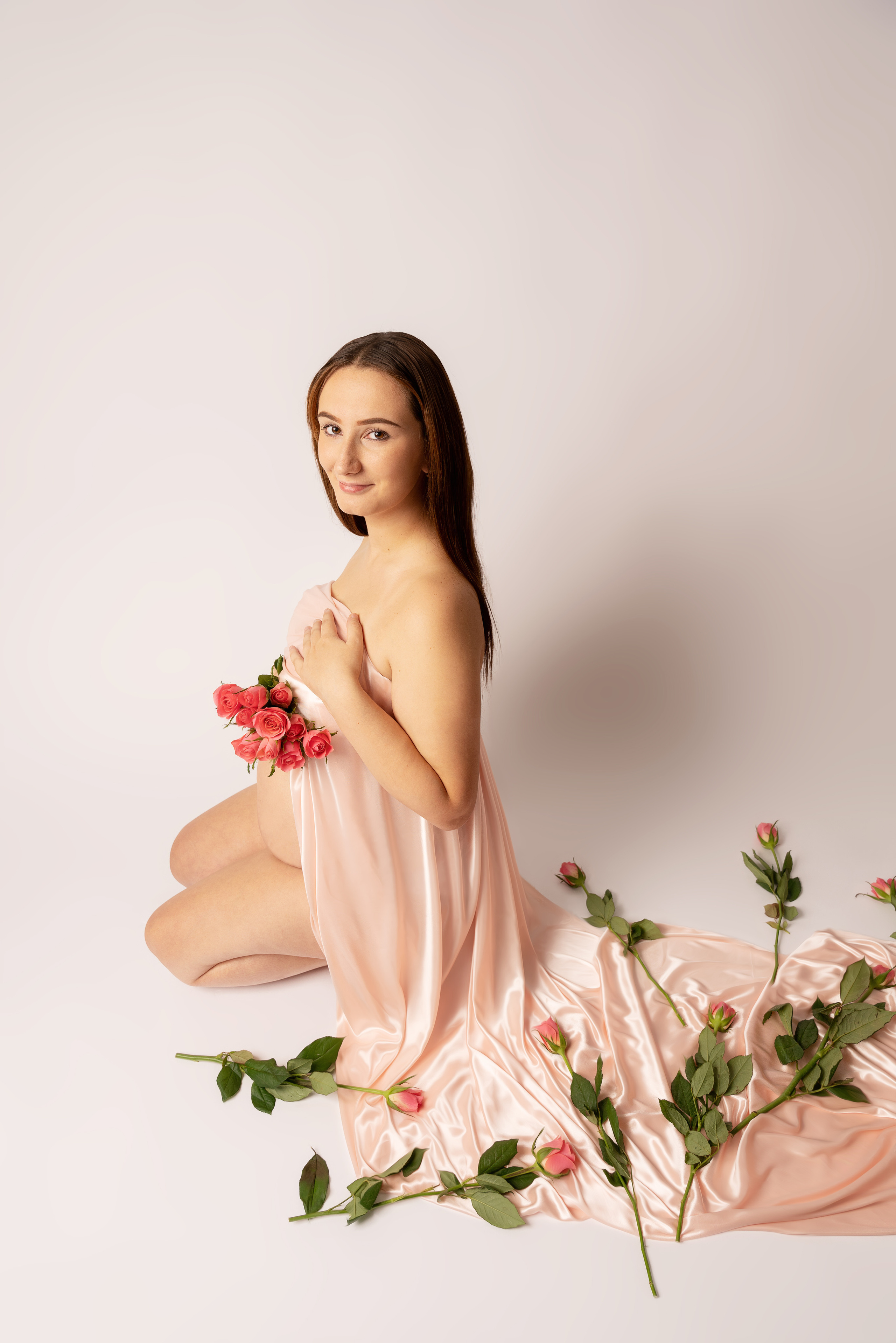 Leichtes und luftiges Foto eines schwangeren Mädchens mit Rosen